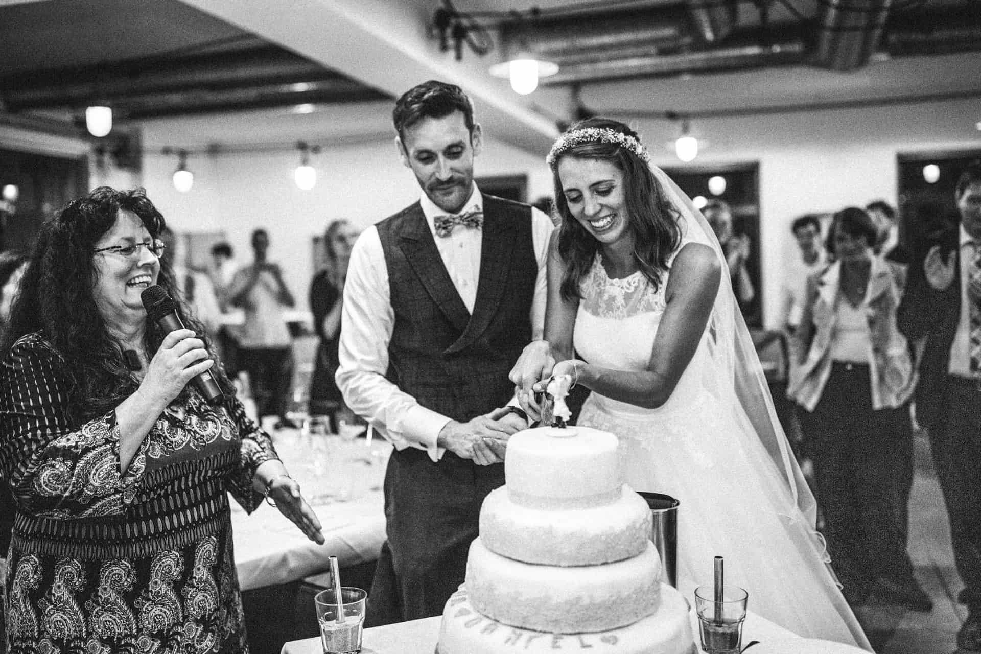Brautpaar schneidet die Hochzeitstorte an in Schwarz-Weiß