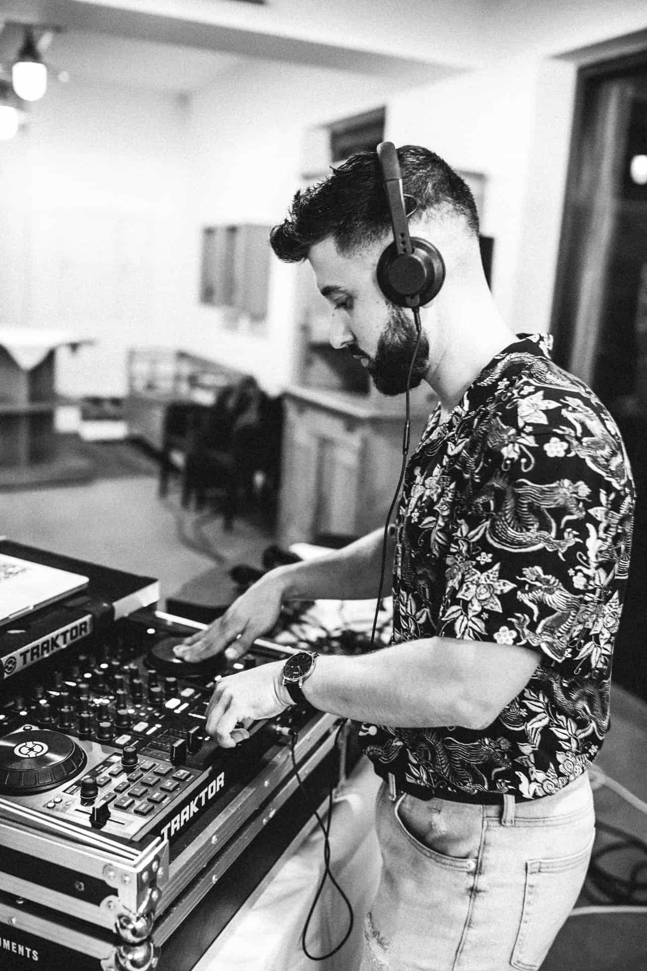DJ mit Kopfhörern am Mischpult in Schwarz-Weiß