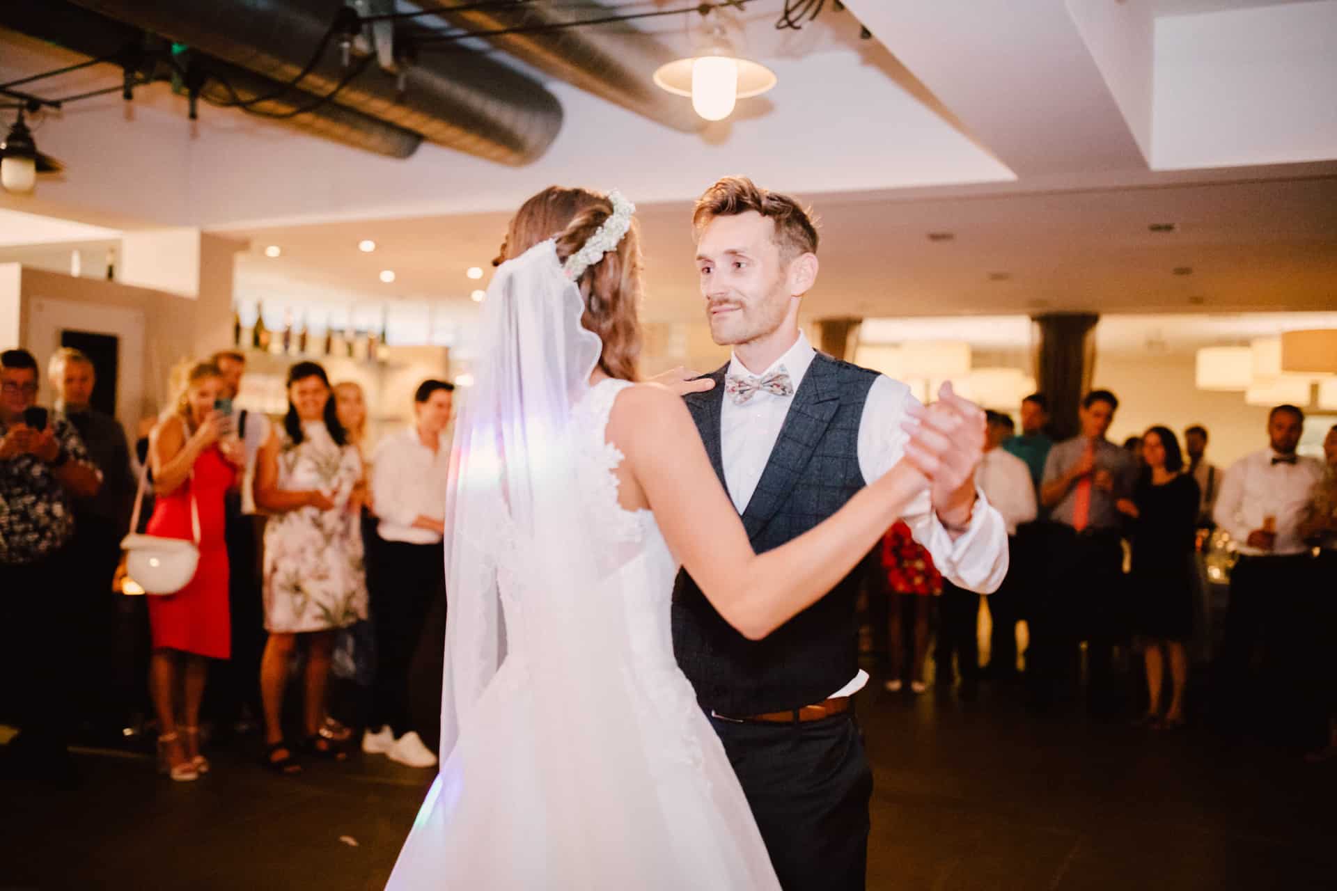 Brautpaar beginnt seinen Hochzeitstanz vor den Gästen