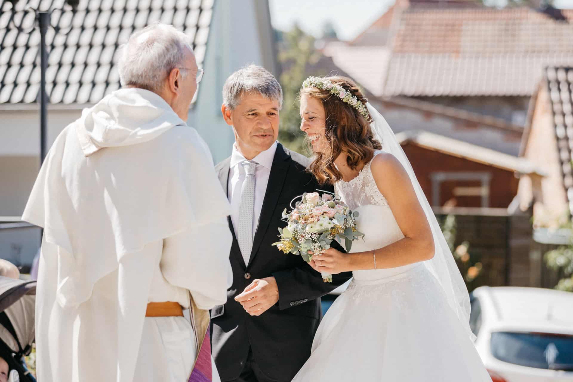 Braut und Begleiter sprechen mit dem Geistlichen