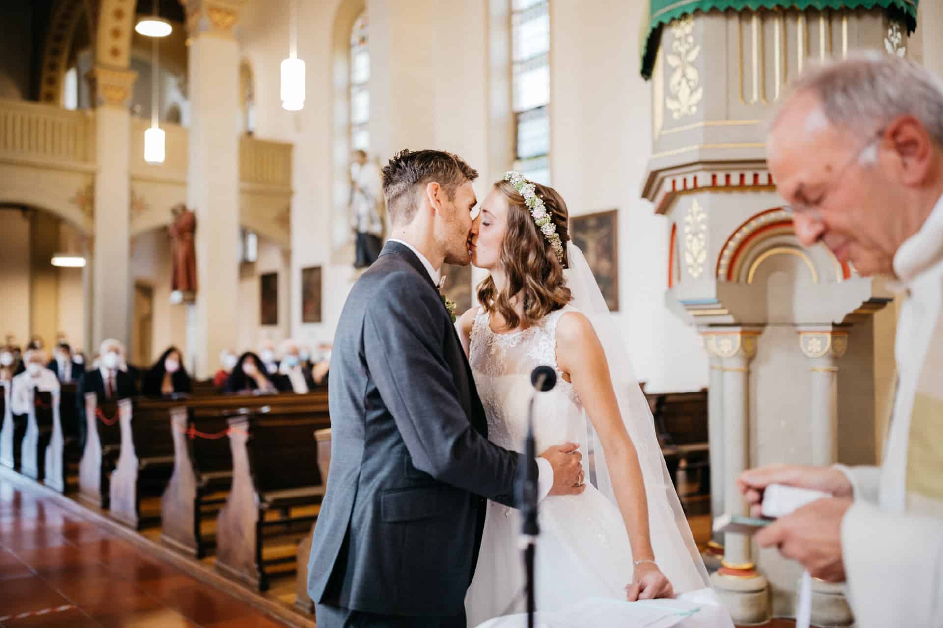 Brautpaar küsst sich vor dem Altar