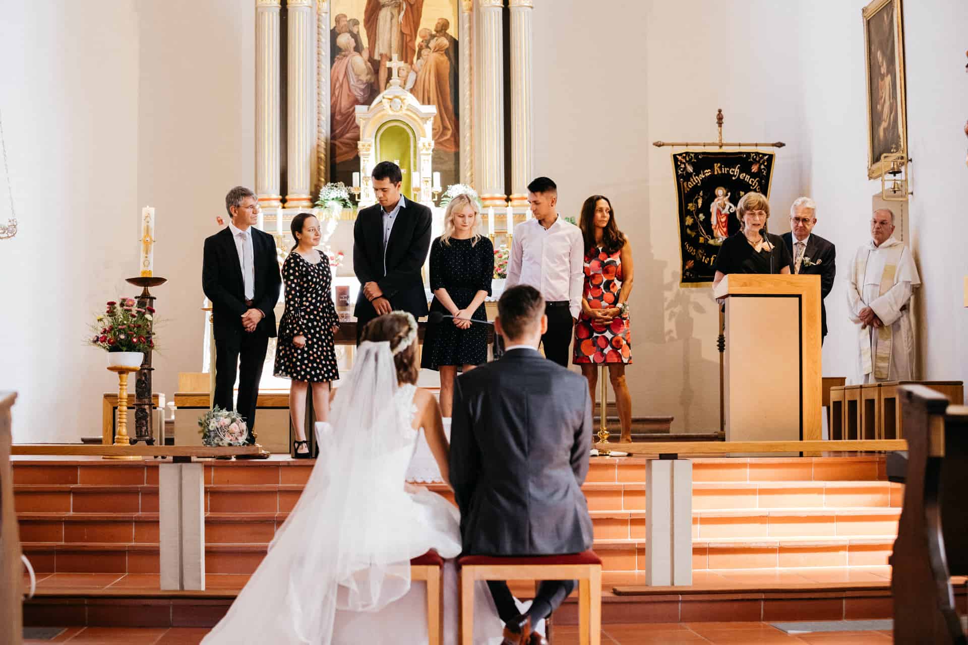 Brautpaar vor Altar und Musikern in der Kirche