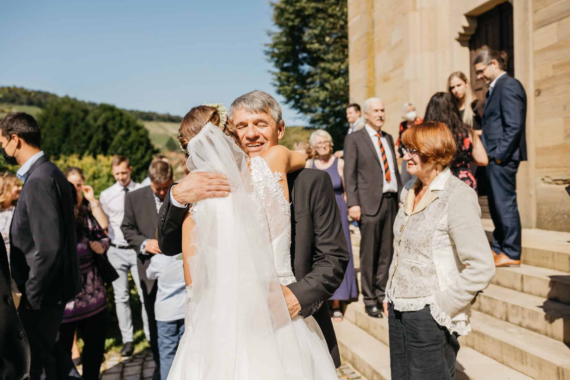 Braut wird auf der Kirchentreppe umarmt