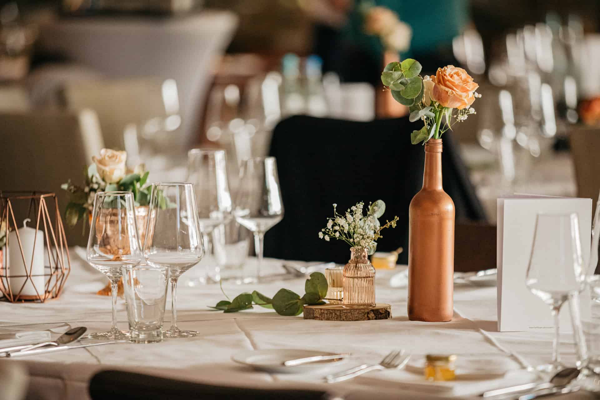 Blumen und goldfarbene Kerzenhalter auf der Hochzeitstafel
