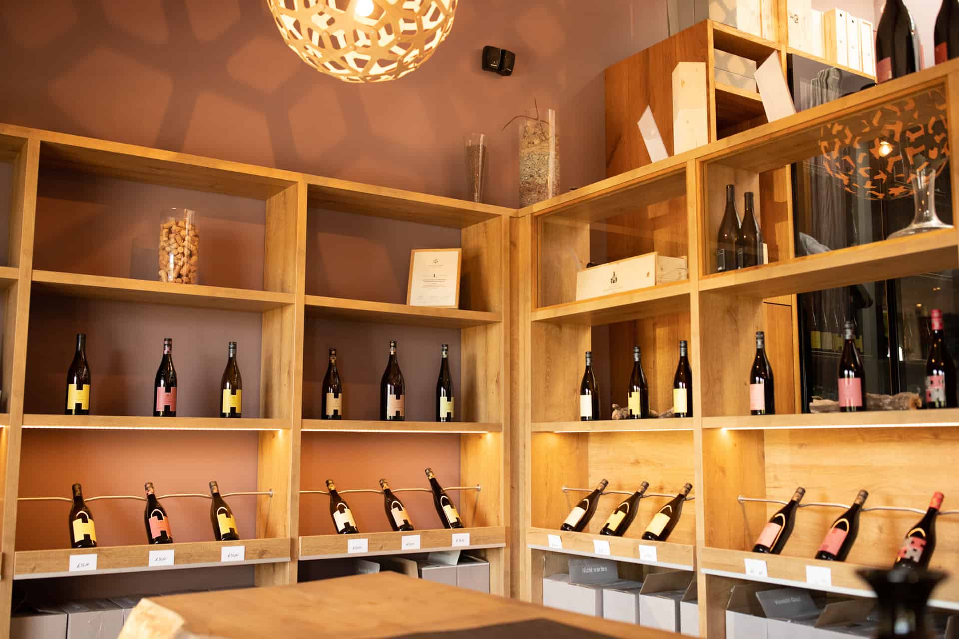 Holzregale mit Weinflaschen am Weingut Heitlinger