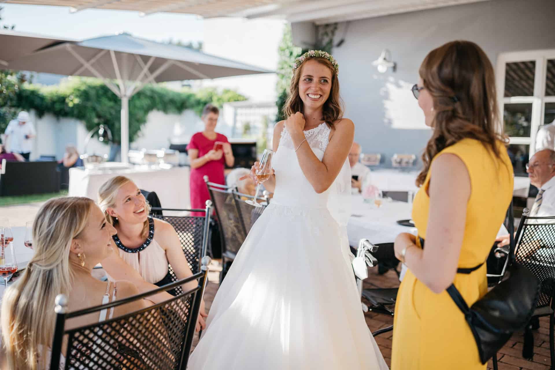 Braut unterhält sich mit Gästen auf der Terrasse