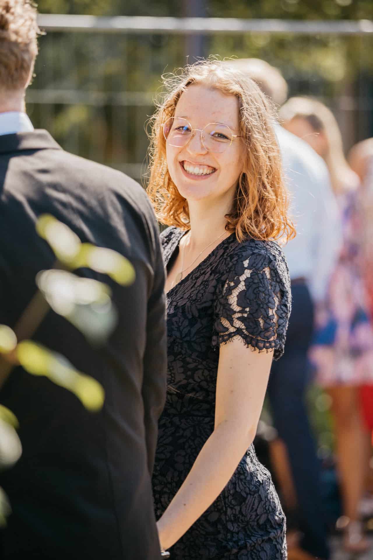 Lächelnder Hochzeitsgast im dunklen Kleid