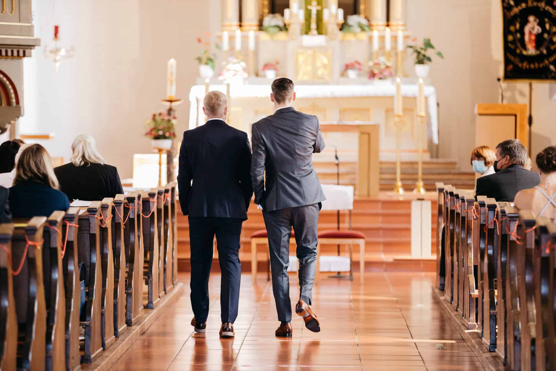 Zwei Gäste gehen durch den Mittelgang zum Altar
