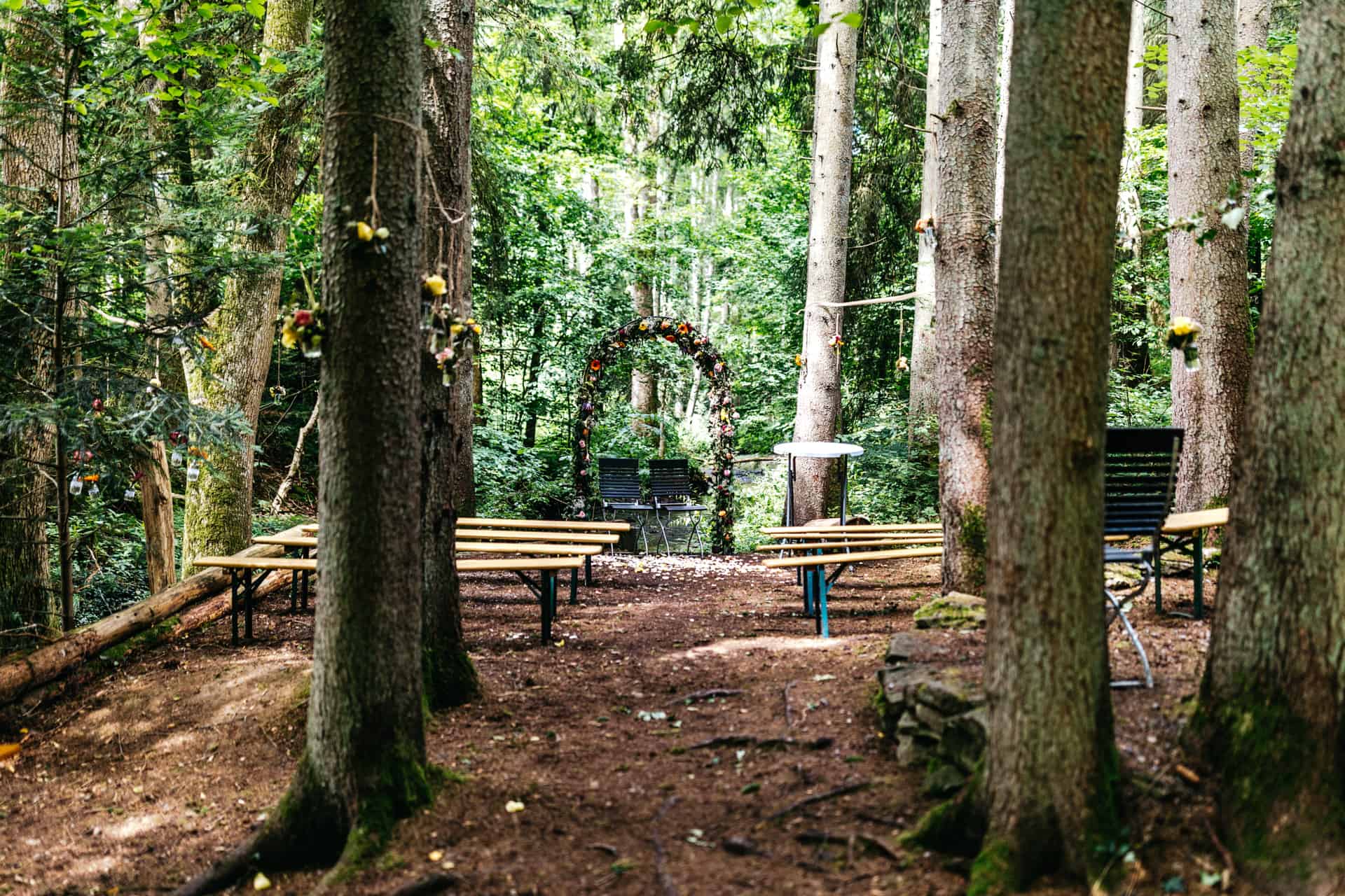 Holzbänke für eine freie Trauung im Wald.