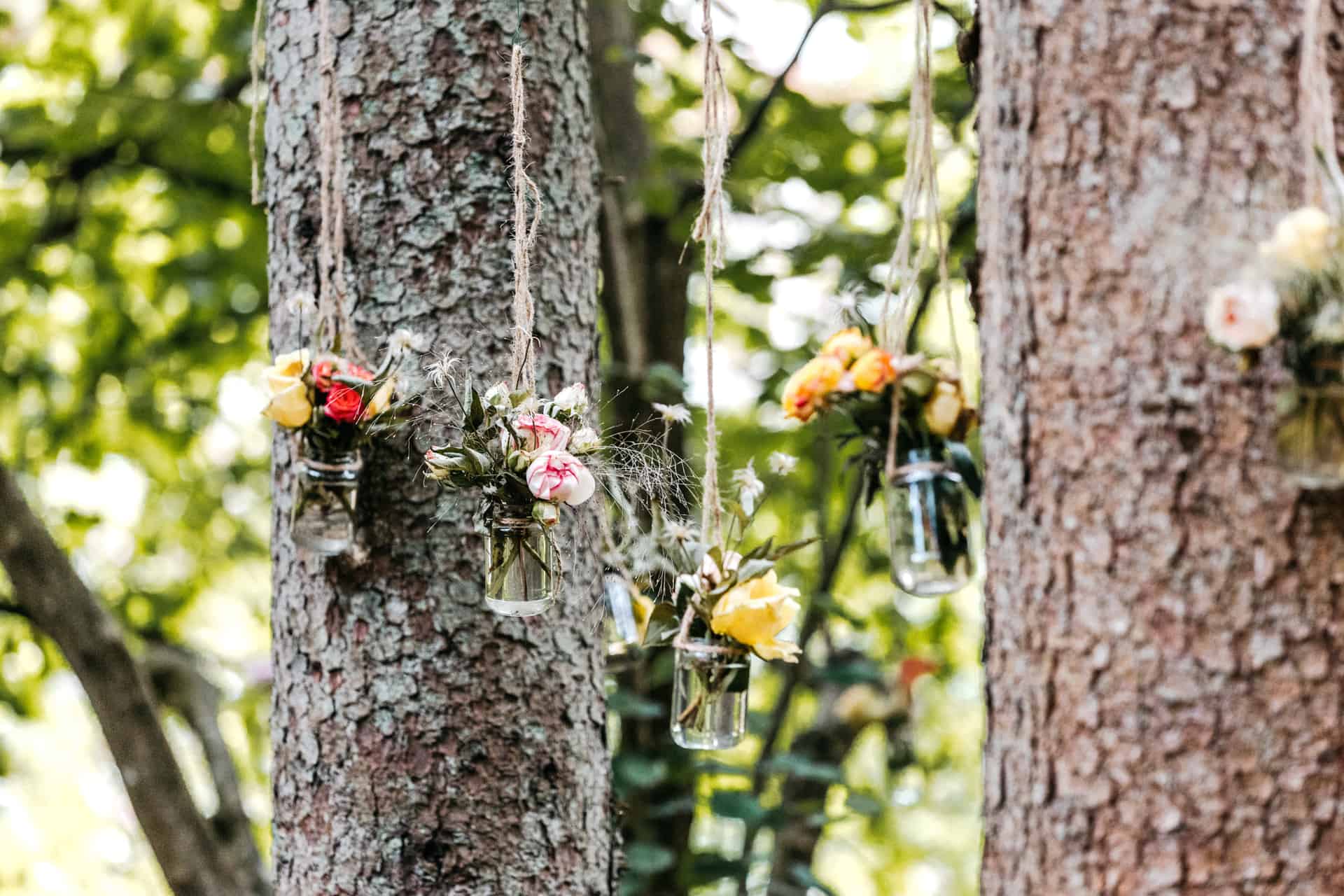 Blumenschmuck an den Bäumen beim Trauplatz im Wald.