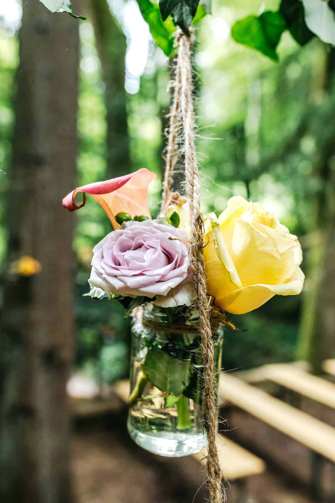 Kleine Blumenarrangements hängen an einem Birkenstamm.