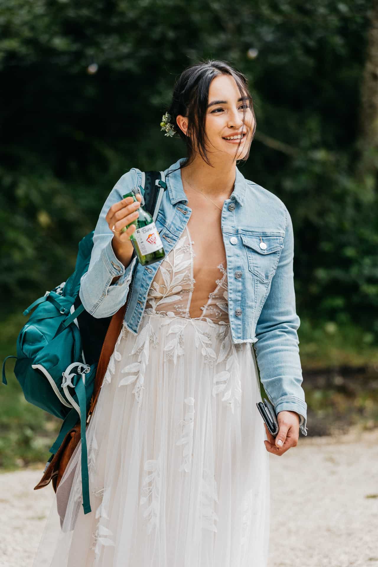 Die Braut trägt eine Jeansjacke über ihrem Hochzeitskleid.