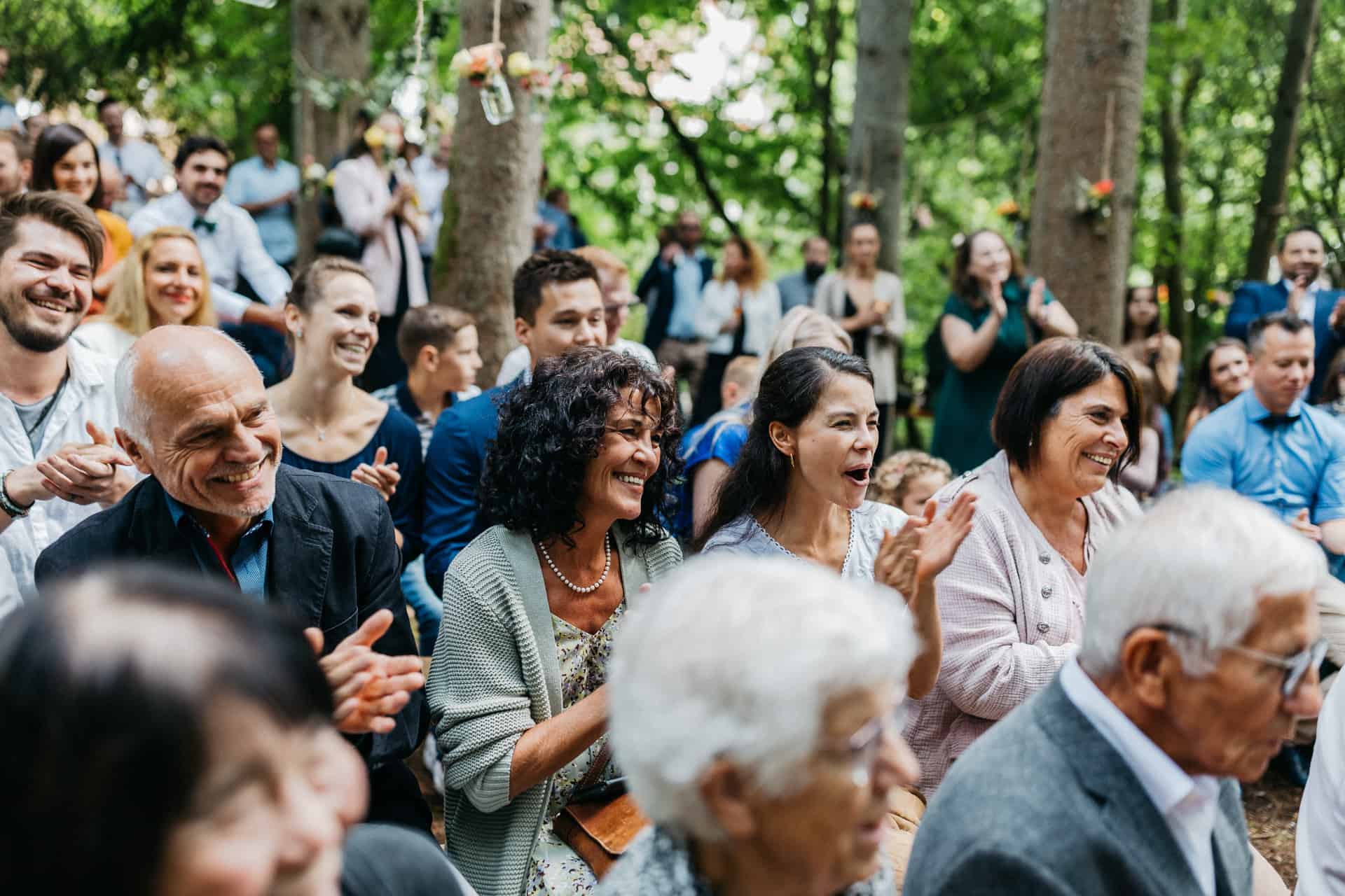 Gäste verfolgen die freie Trauung im Wald