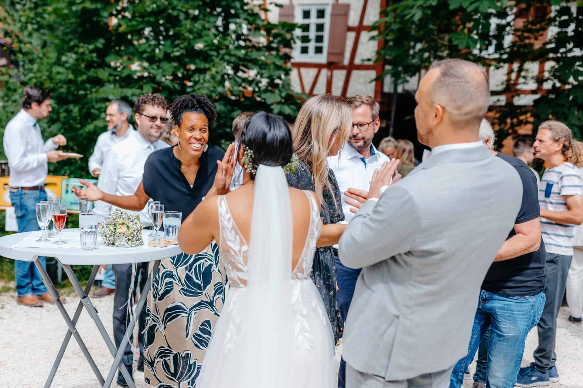 Das Brautpaar applaudiert beim Empfang im Hof der Hagmühle.