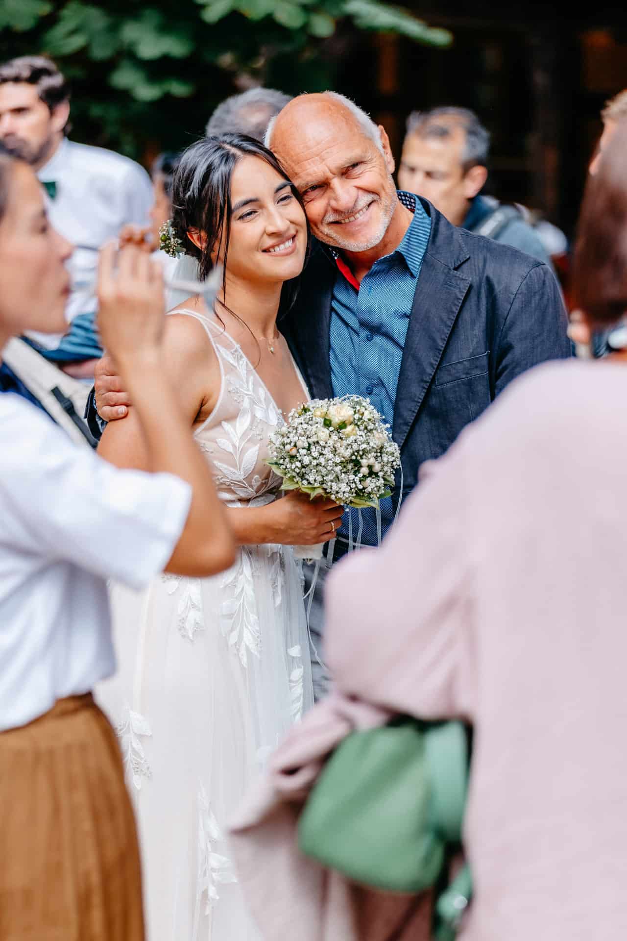 Braut posiert mit zwei Gästen für ein Erinnerungsfoto