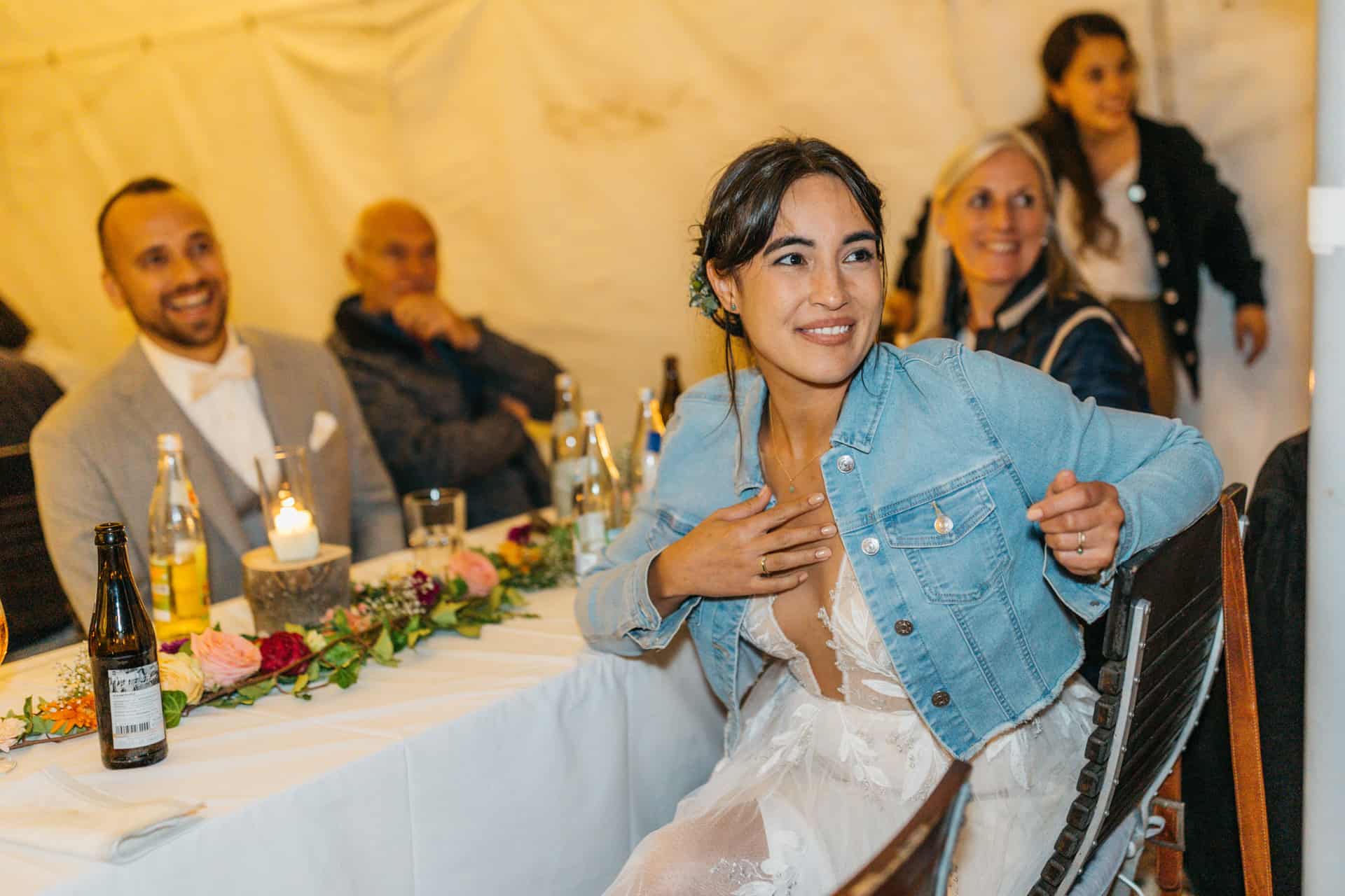 Brautpaar sitzt lachend an der Hochzeitstafel