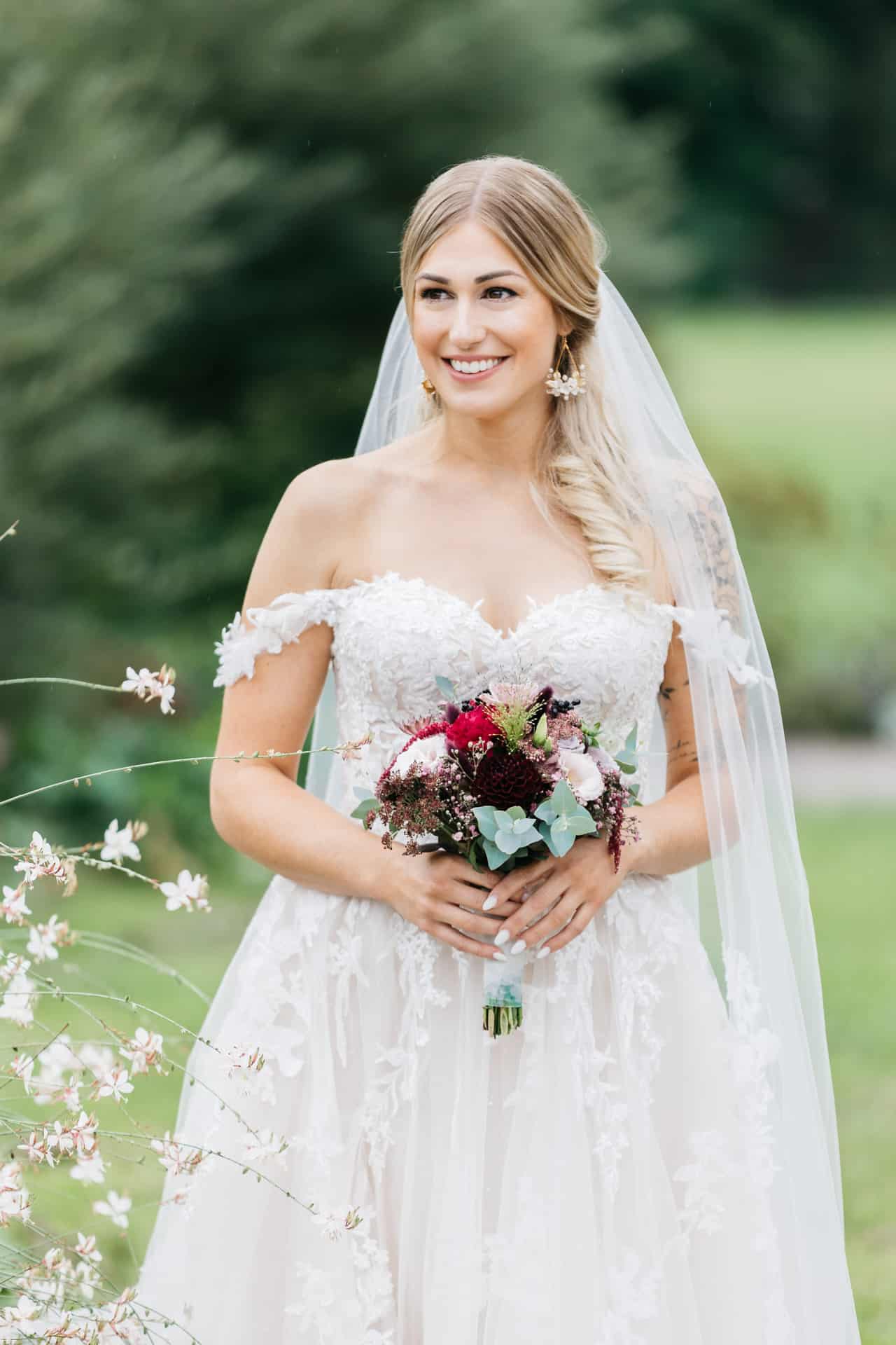 Porträt der Braut mit rot-weißem Blumenstrauß