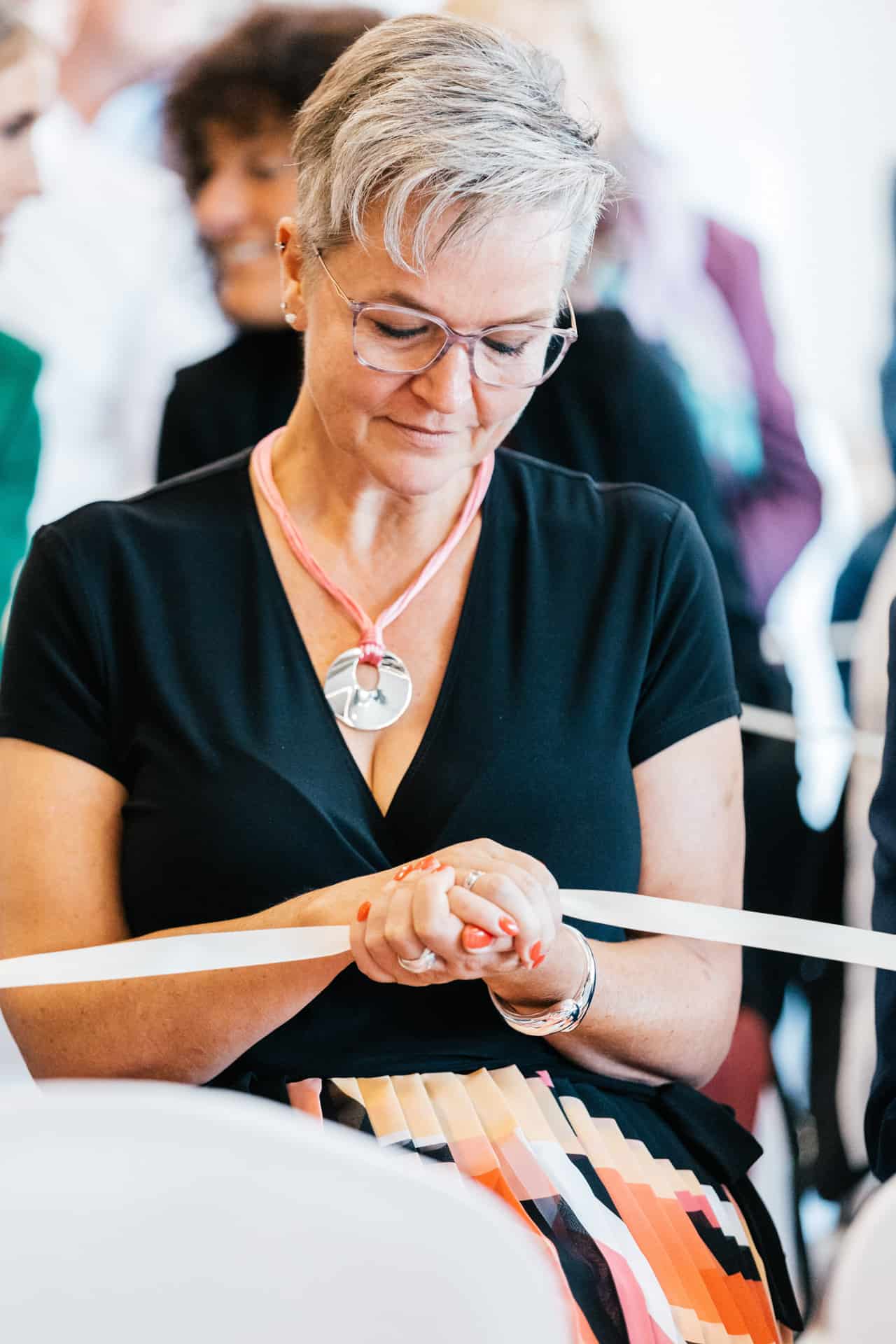 Hochzeitsgast hält das Band mit den Trauringen