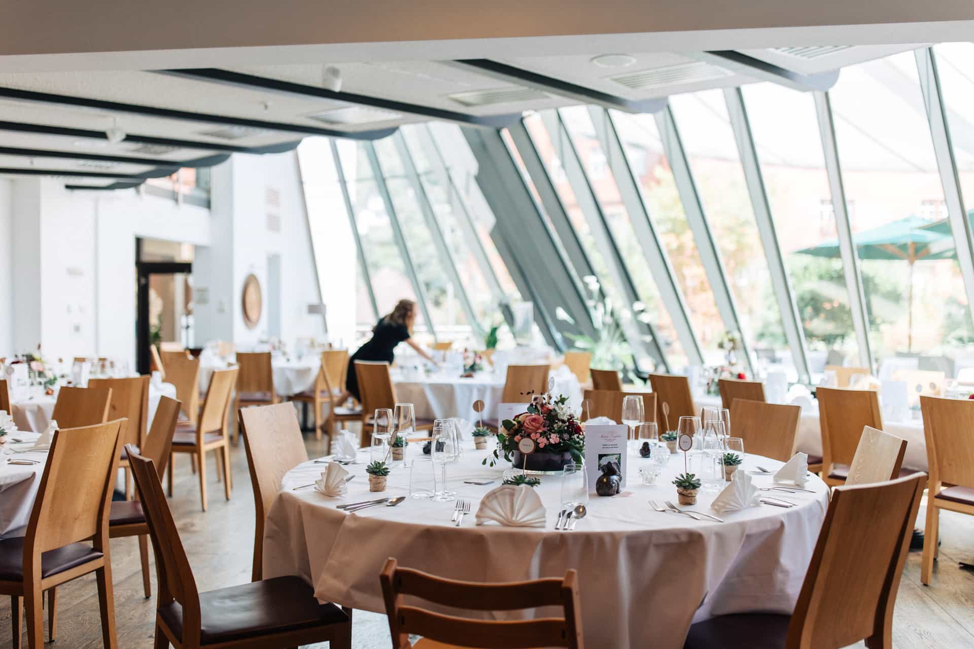 Heller Wintergarten mit gedeckten Hochzeitstischen