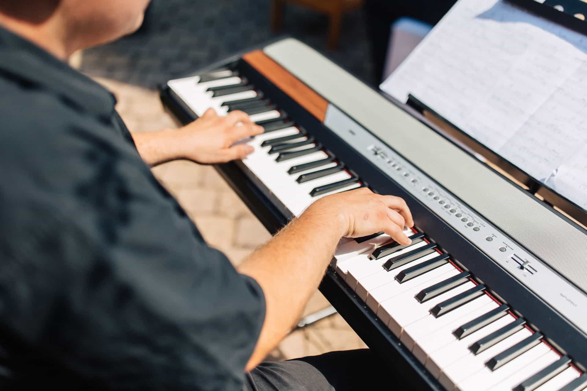 Hände eines Musikers auf den Tasten eines Keyboards