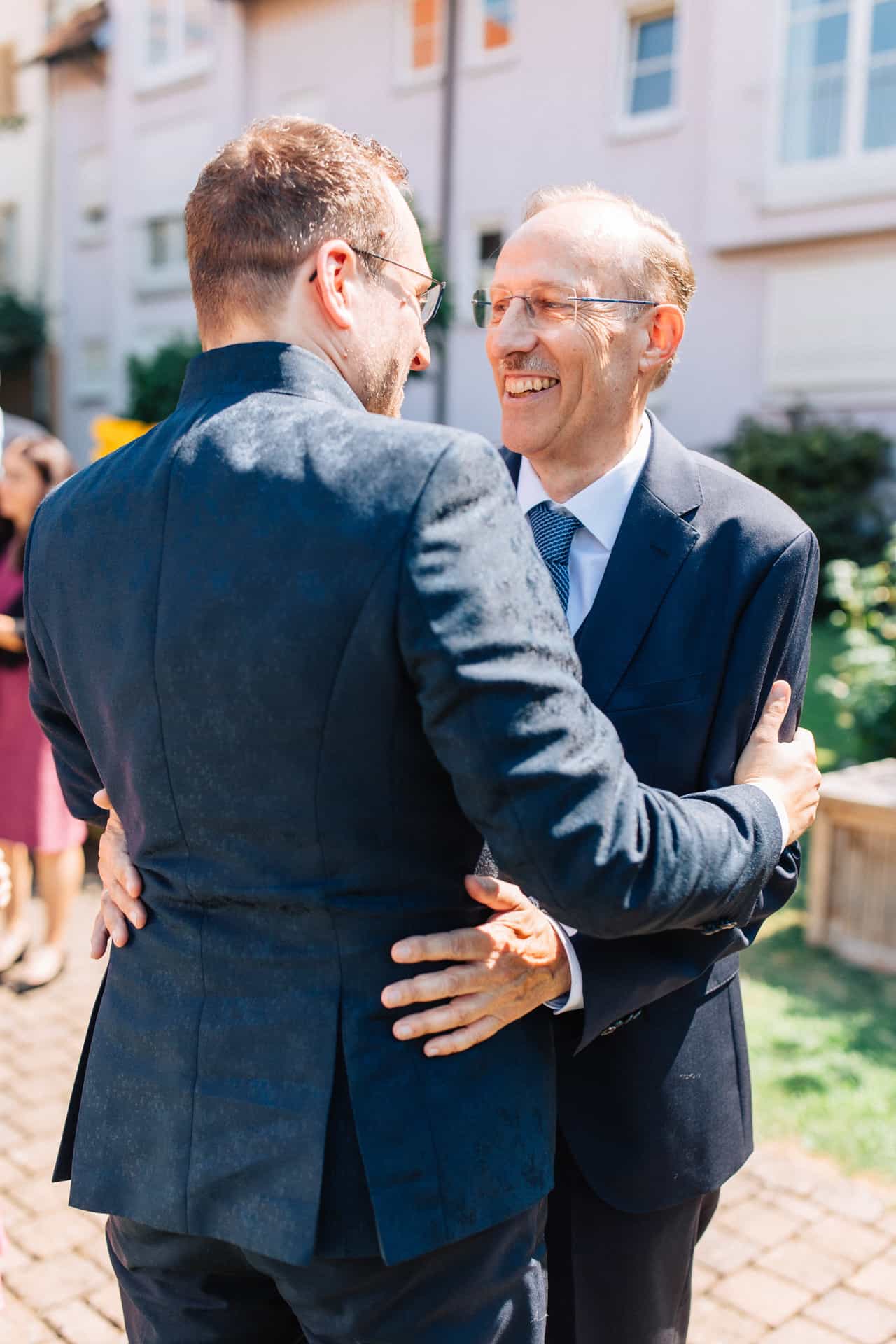 Bräutigam umarmt einen älteren Gast