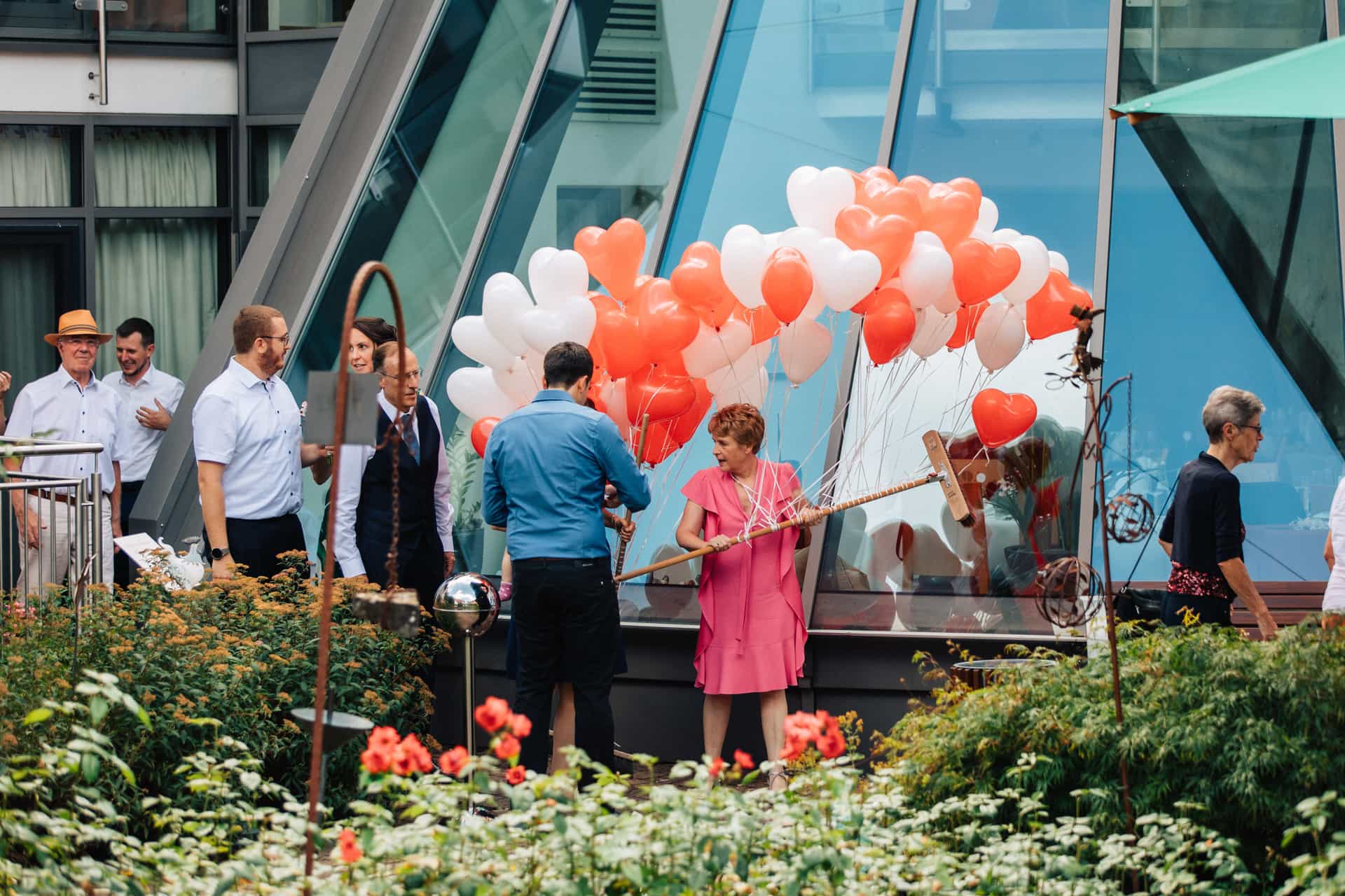 Hochzeitsgesellschaft mit weißen und orangefarbenen Luftballons