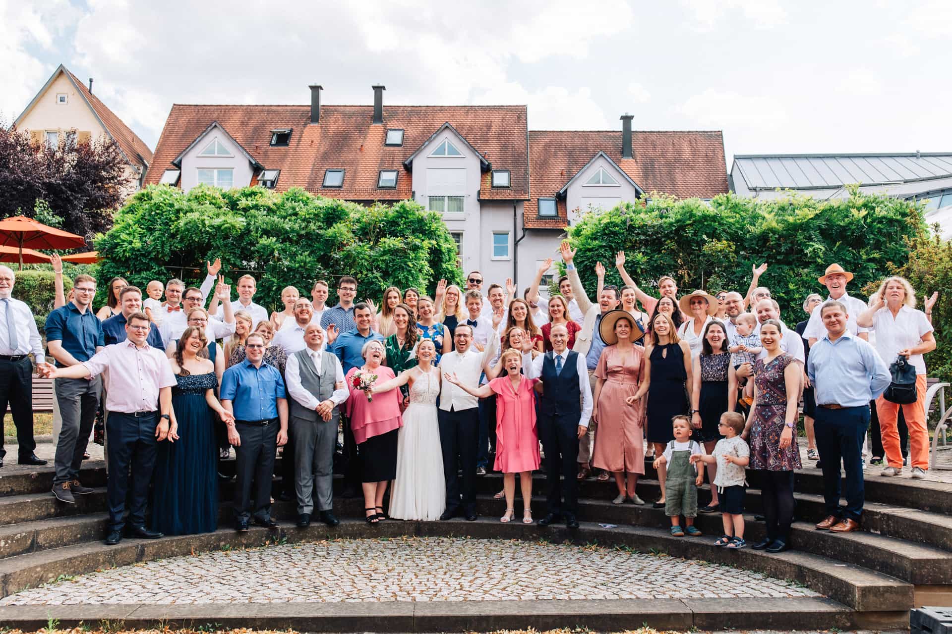 Großes Gruppenfoto der Hochzeitsgesellschaft im Garten