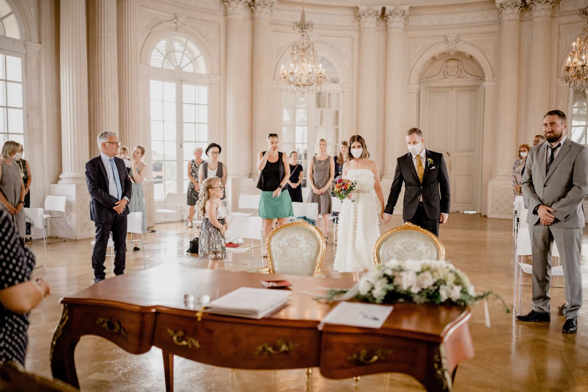 Das Brautpaar steht vor dem Trautisch im Schlosssaal.