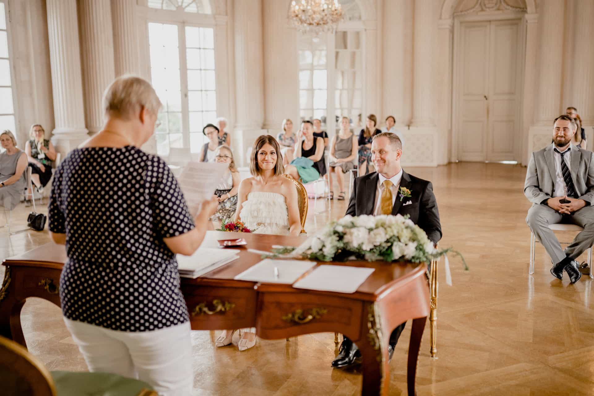 Blick über die Schulter der Standesbeamtin zur Gesellschaft