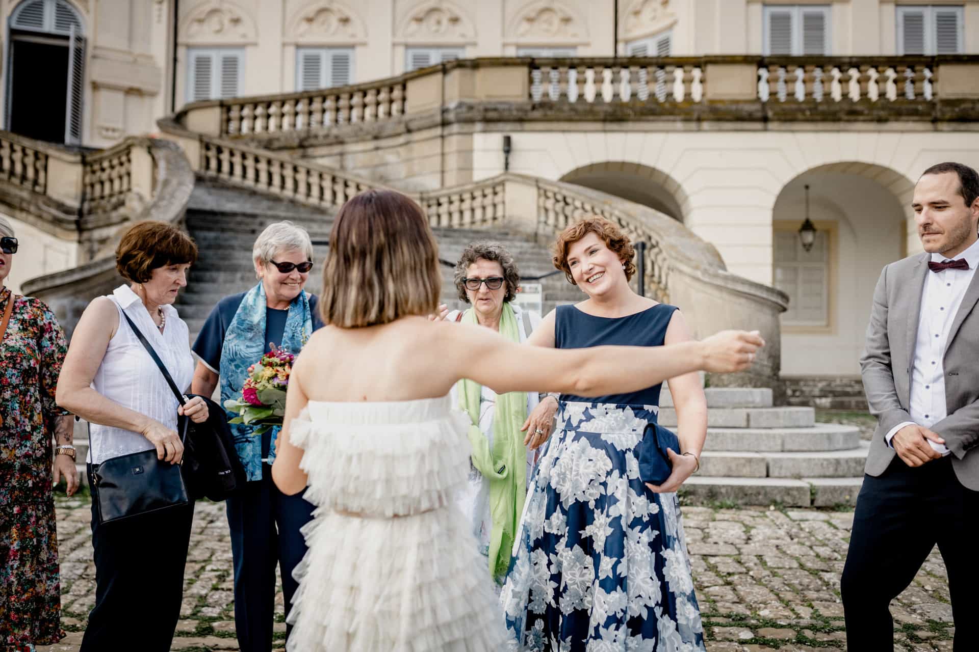Braut wird vor dem Schloss umarmt