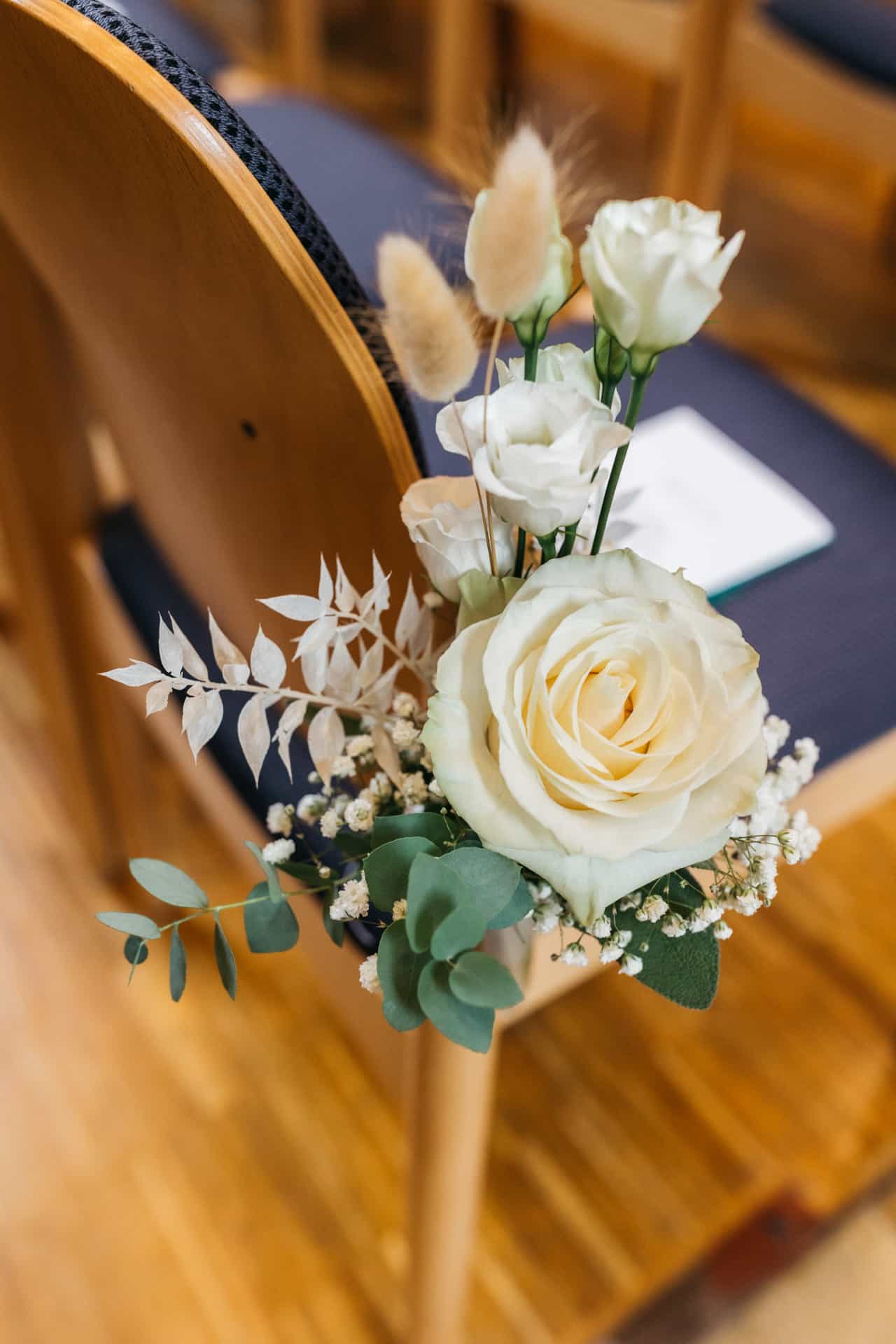 Weiße Rosen als Blumenschmuck an einer Kirchenbank