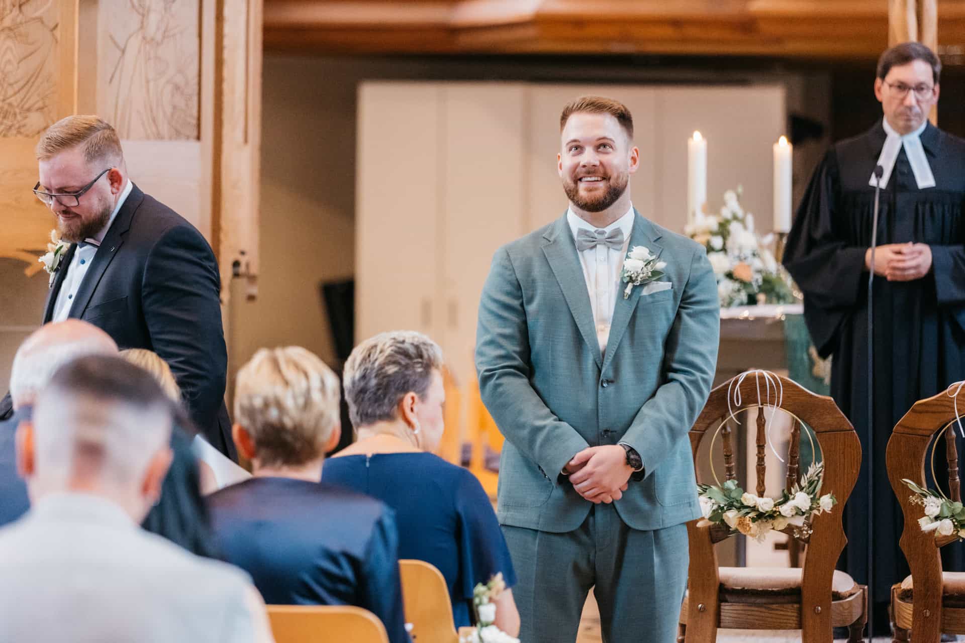Bräutigam wartet lächelnd in der Kirche