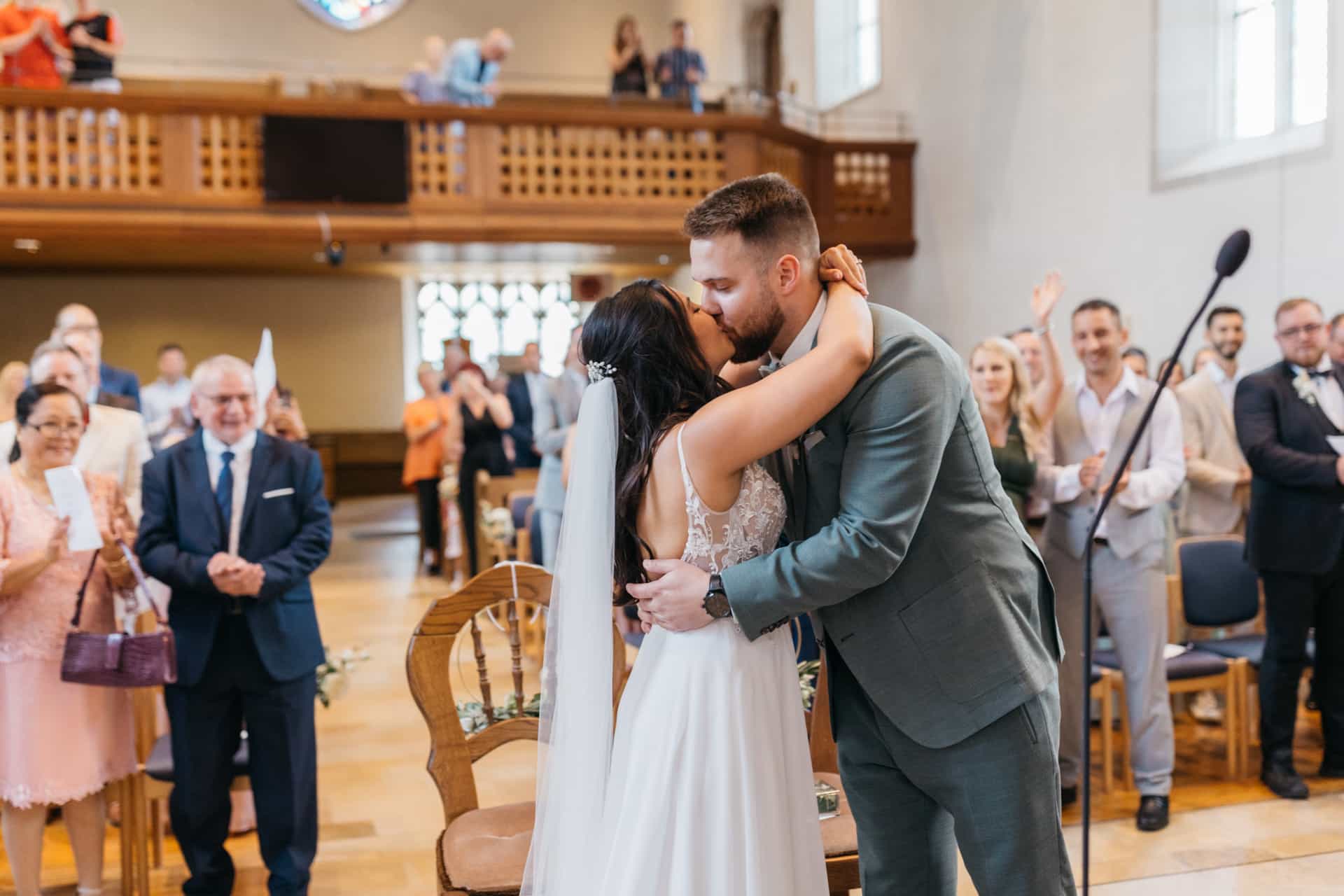 Brautpaar küsst sich vor dem Altar