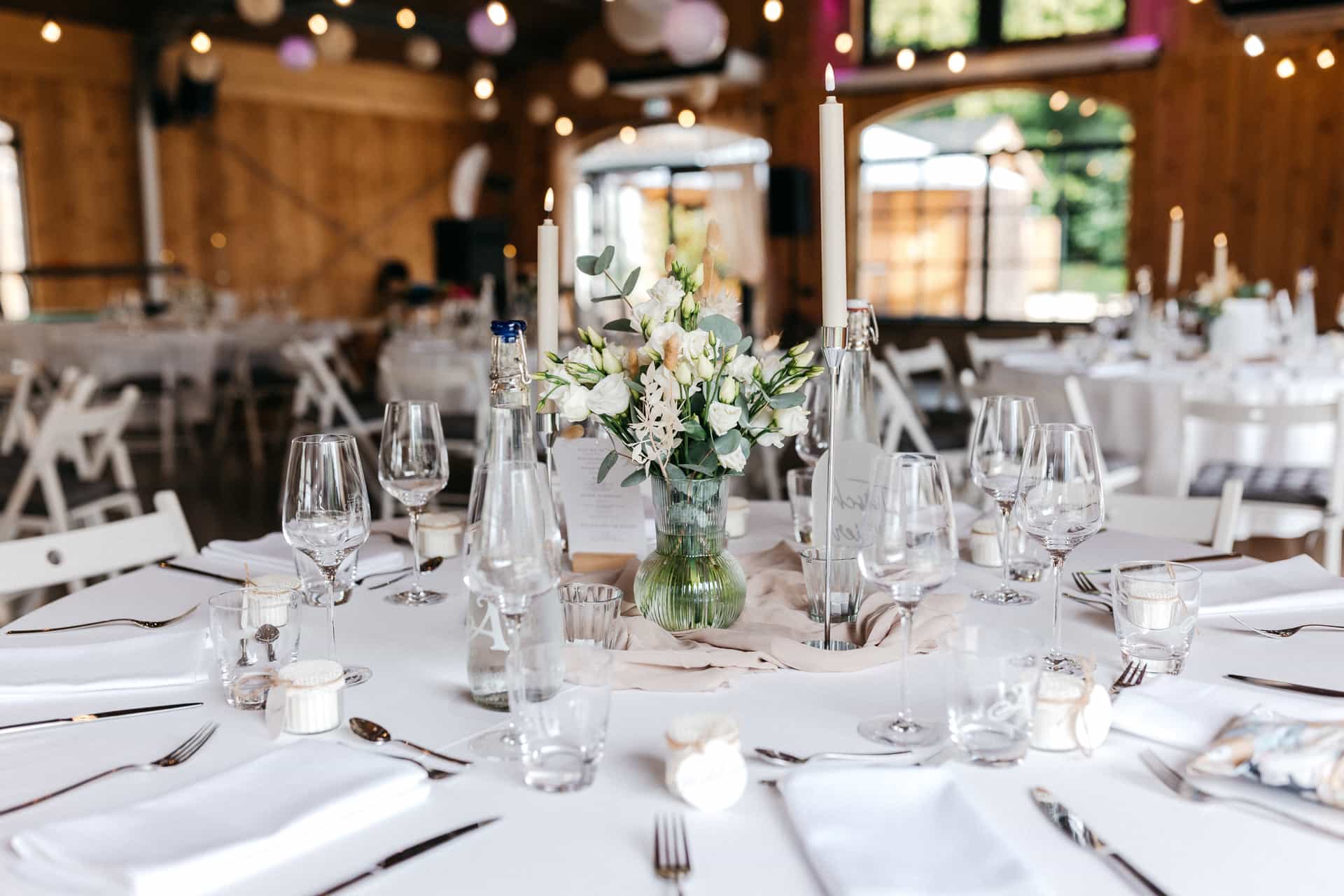 Blick über eine runde Hochzeitstafel im dekorierten Saal