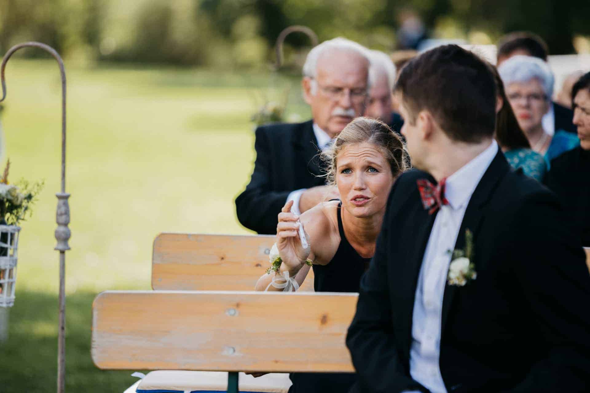 Ein Hochzeitsgast hält ein kleines Kind vor der Trauung.