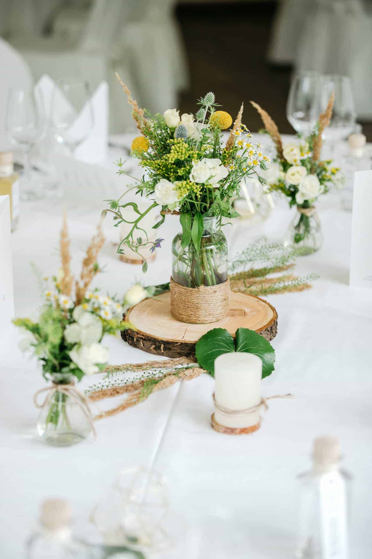 Weiße Blumen und Kerzen auf einer Hochzeitstafel