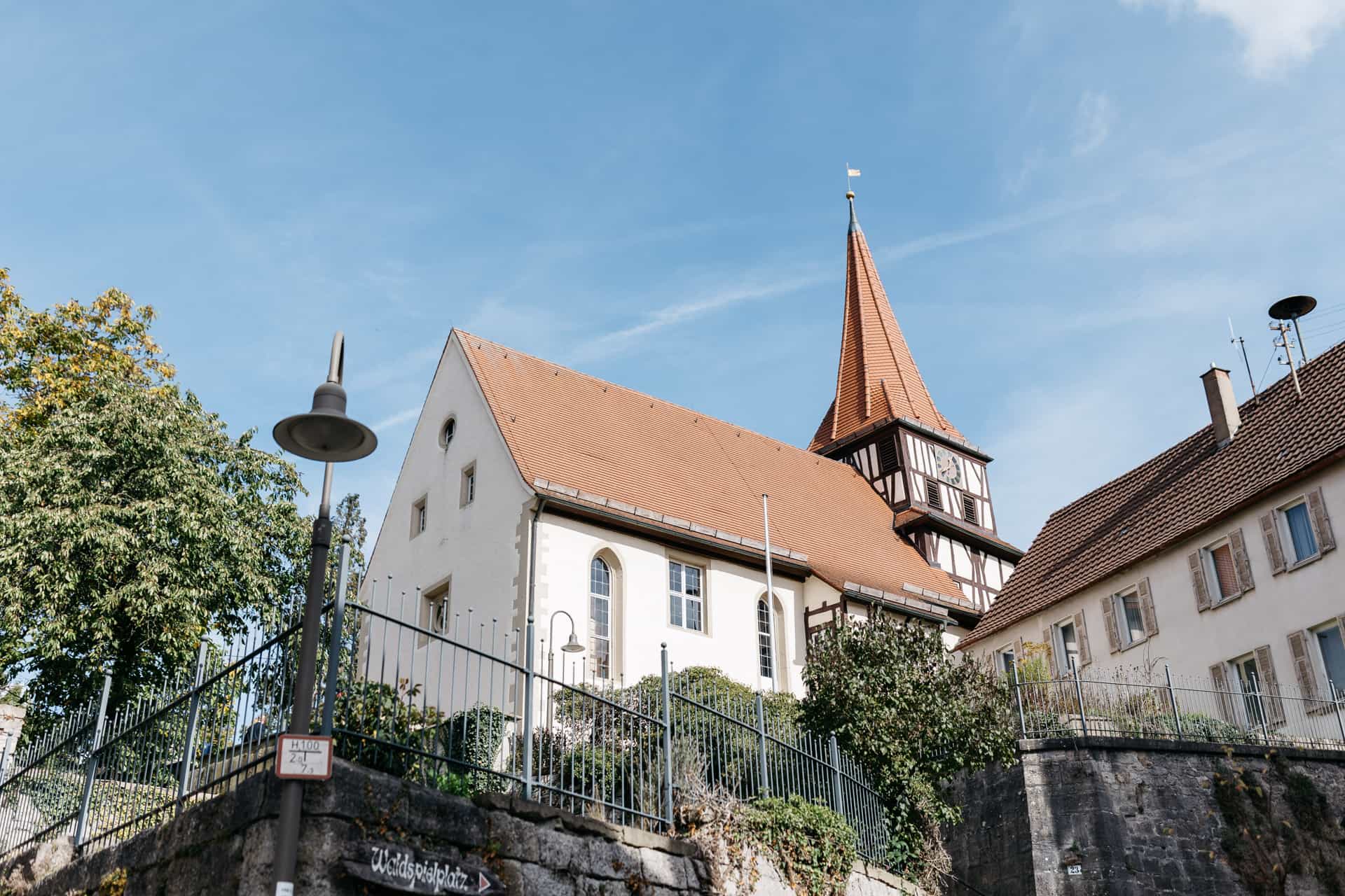 Außenansicht einer Kirche mit spitzem Turm
