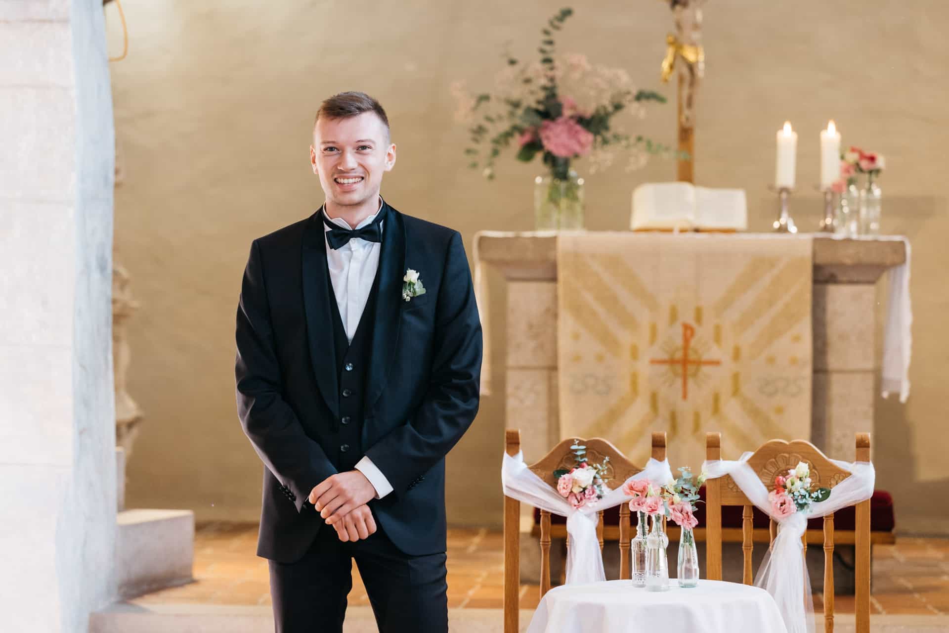 Bräutigam lächelt vor dem Altar