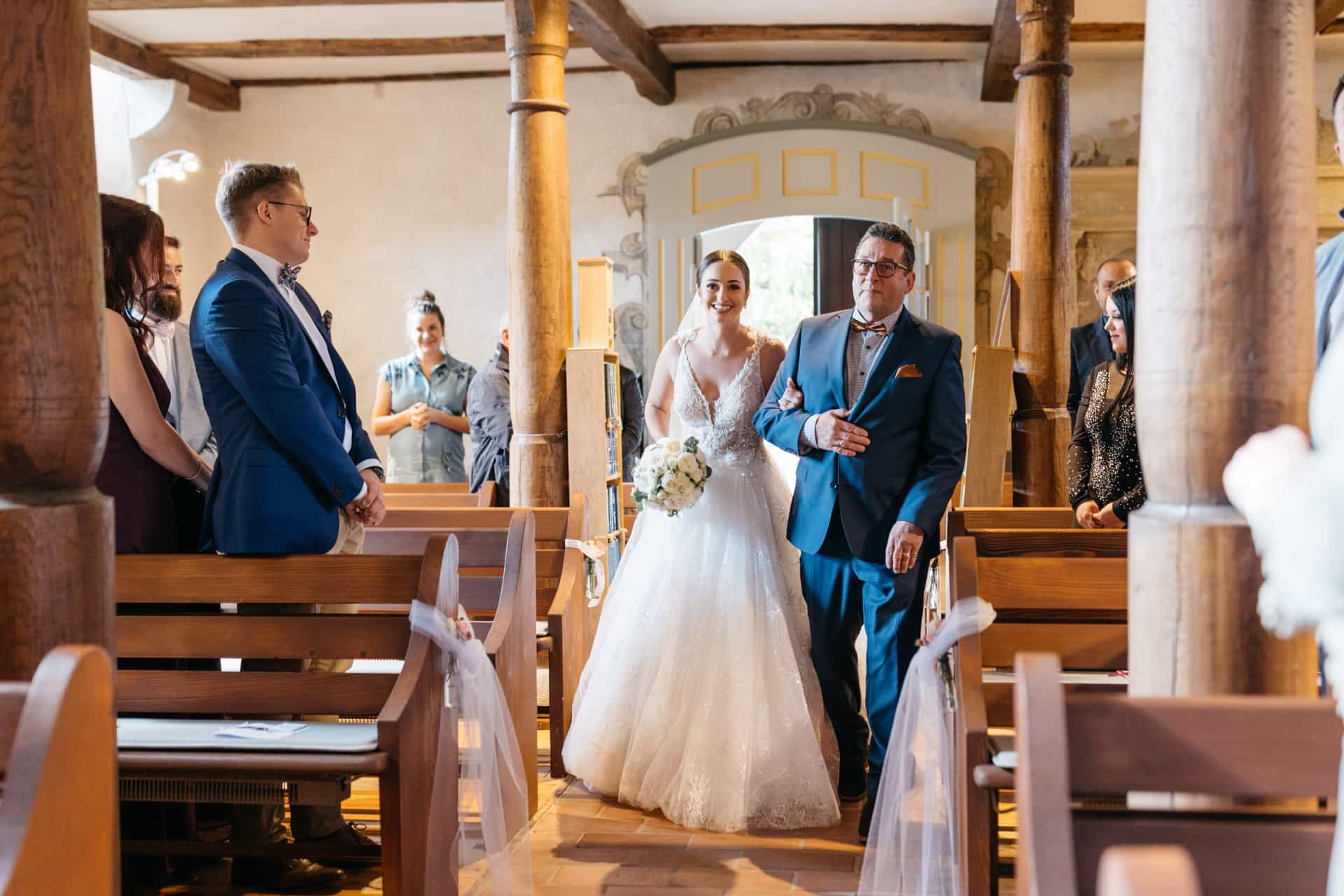 Braut zieht durch die stehenden Gäste in die Kirche ein