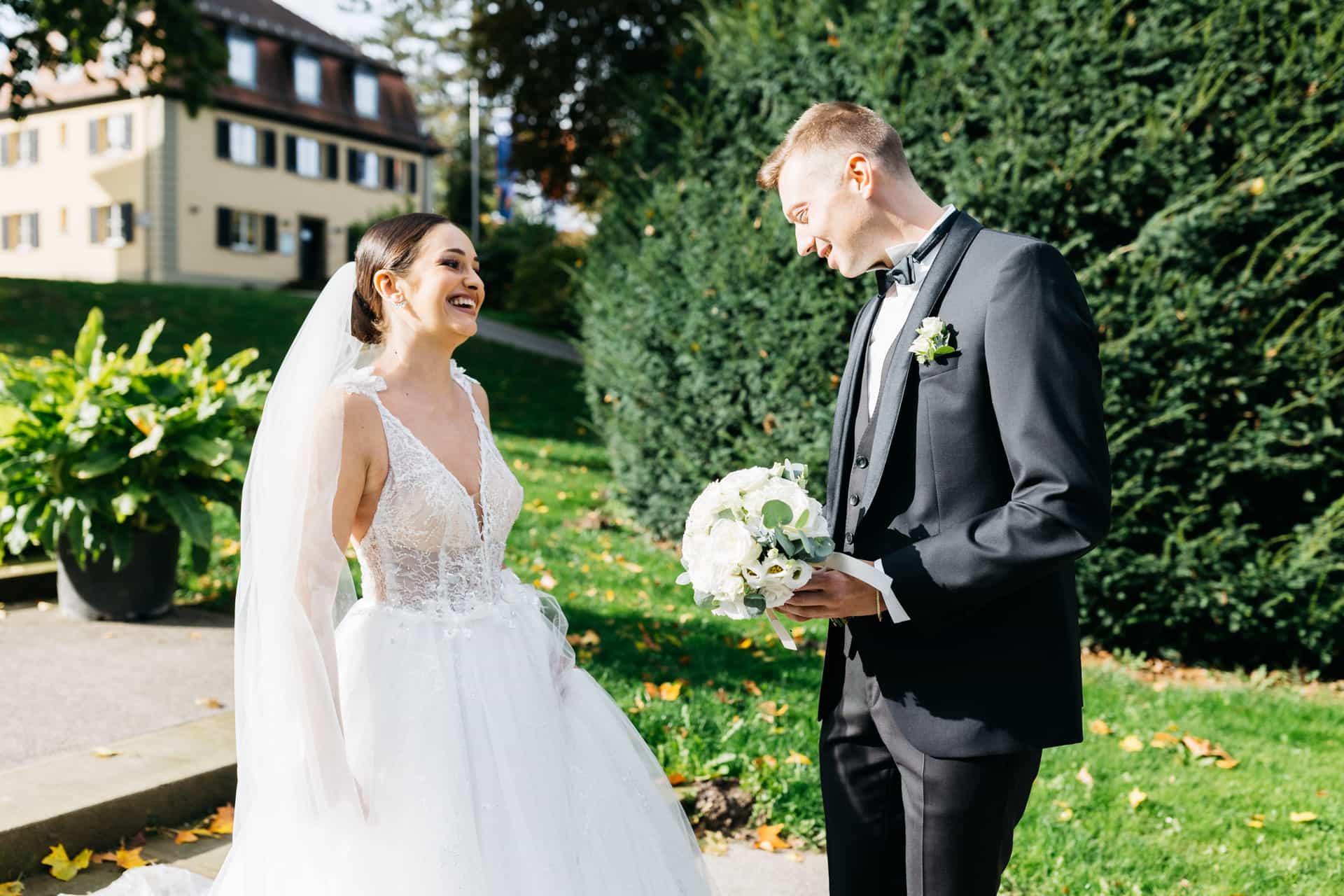 Bräutigam dreht sich mit Blumenstrauß zur Braut um