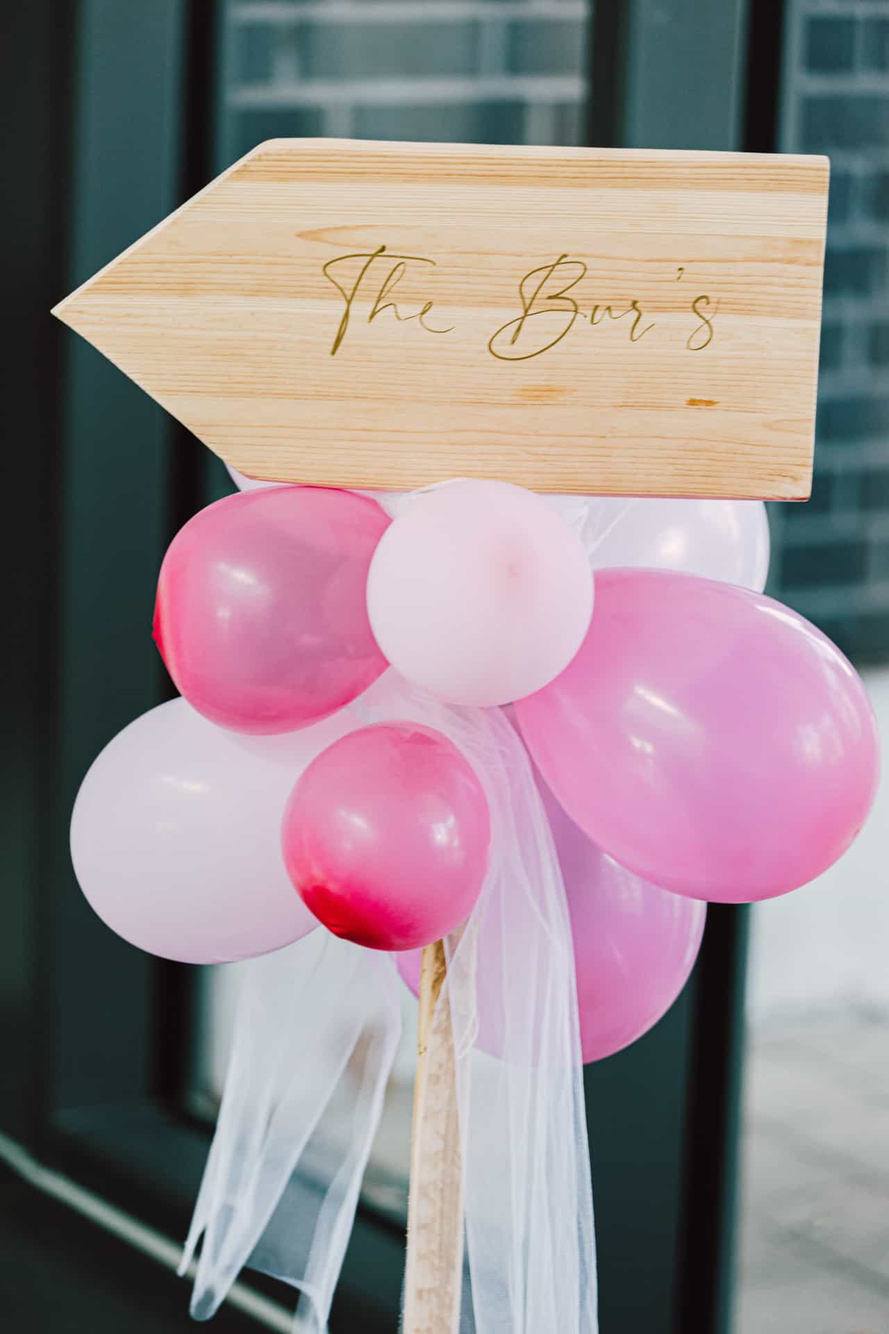 Schild mit rosa Luftballons am Eingang zur Feier