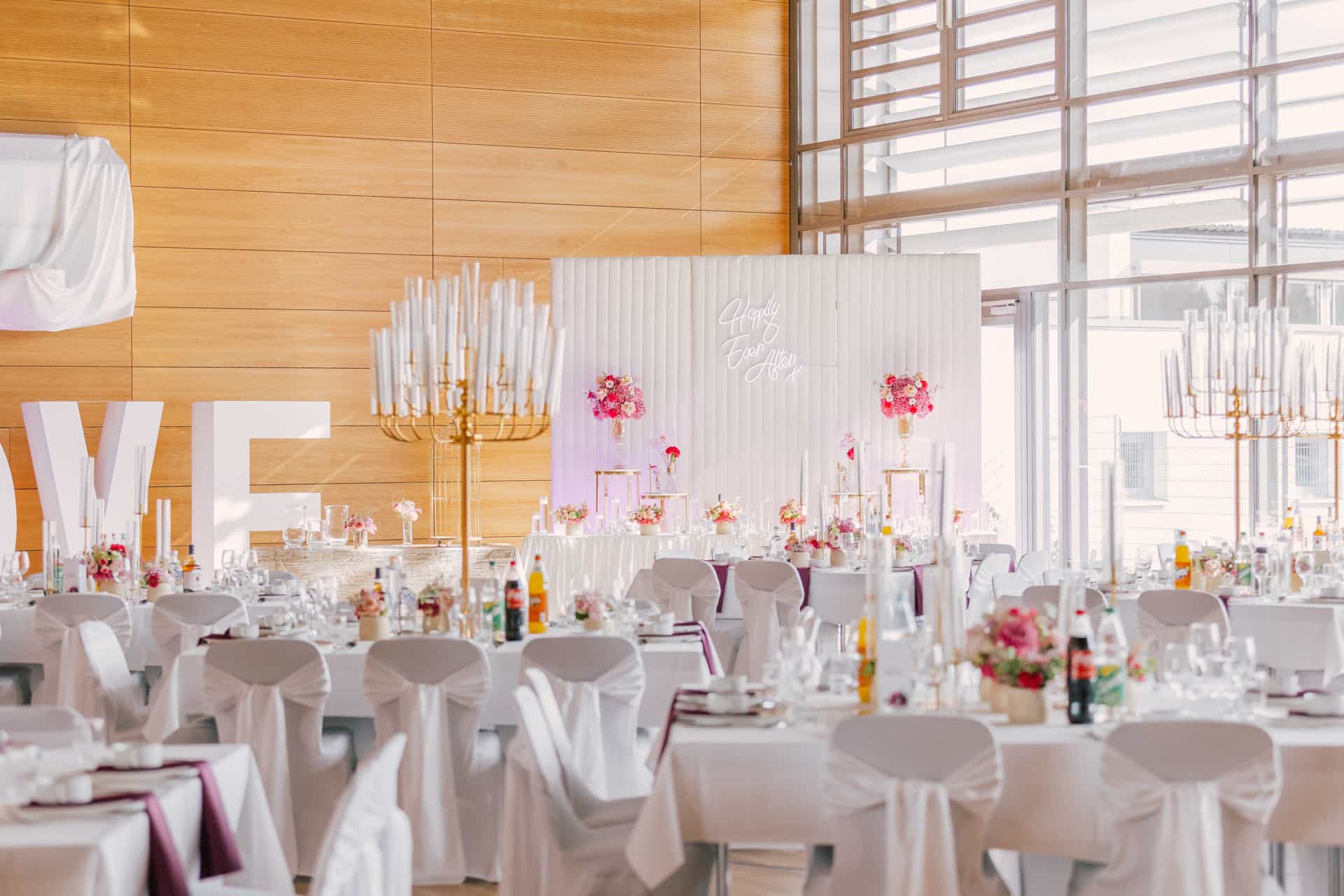 Heller Hochzeitssaal mit weiß gedeckten Tischen