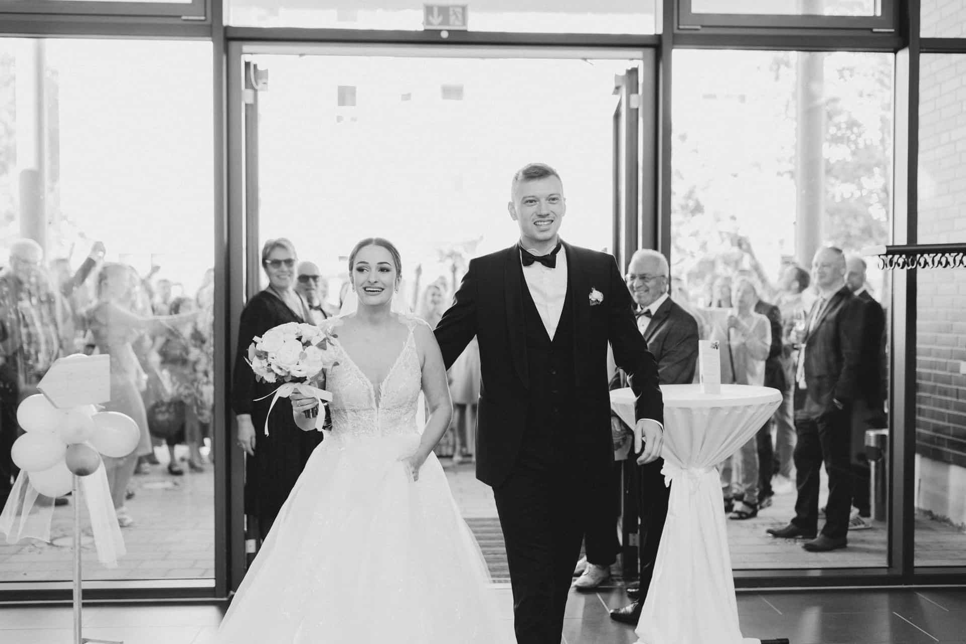 Brautpaar betritt den Hochzeitssaal in Schwarz-Weiß