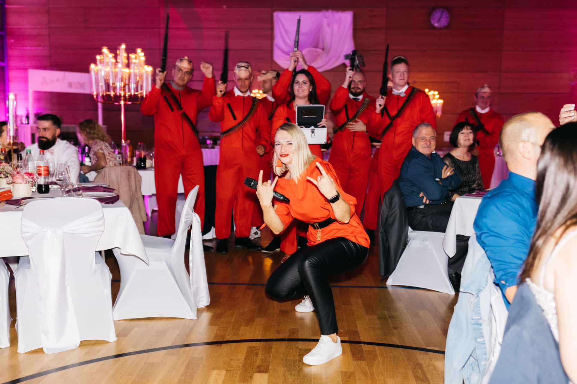 Tanzgruppe in roten Kostümen zwischen den Hochzeitstischen