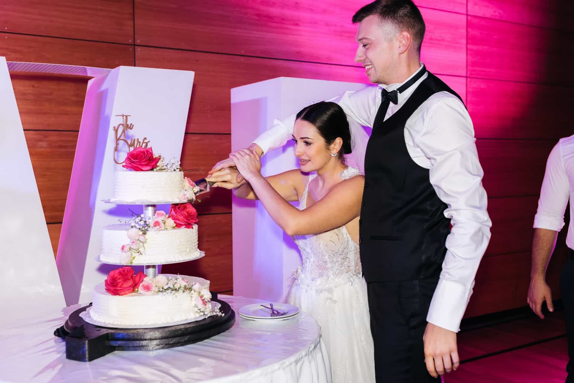 Brautpaar schneidet die mehrstöckige Hochzeitstorte an