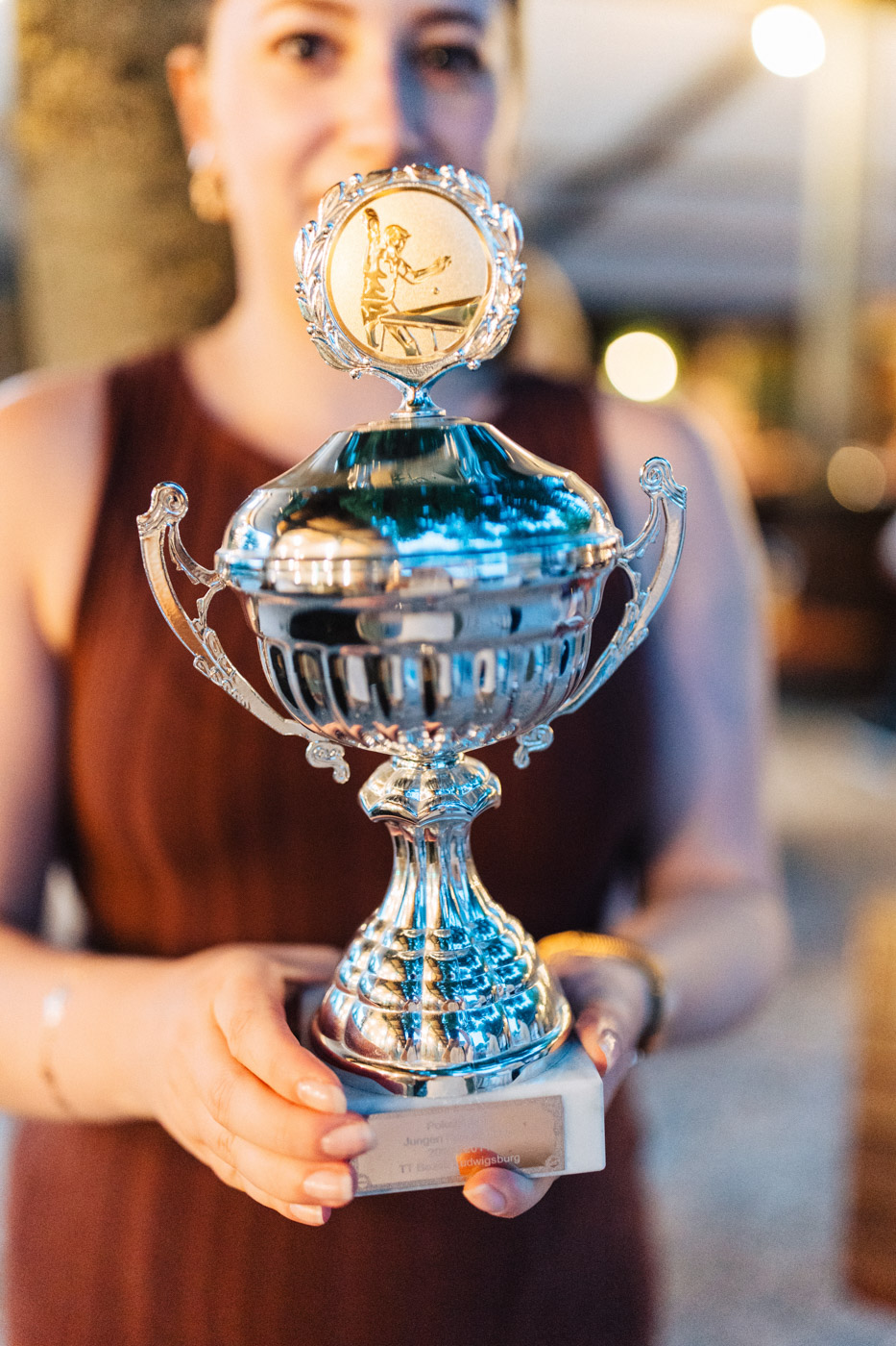 Ein Gast hält einen Pokal bei der Hochzeitsfeier.
