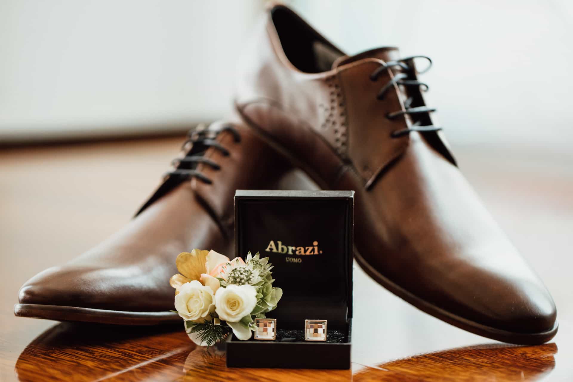 Braune Lederschuhe und Ansteckblume des Bräutigams