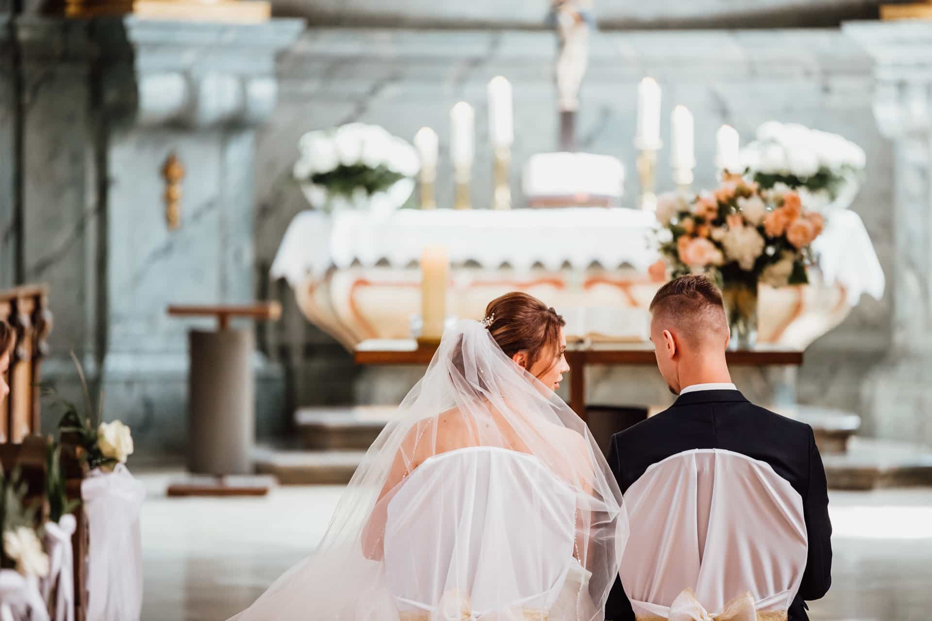 Das Brautpaar kniet vor dem geschmückten Altar.