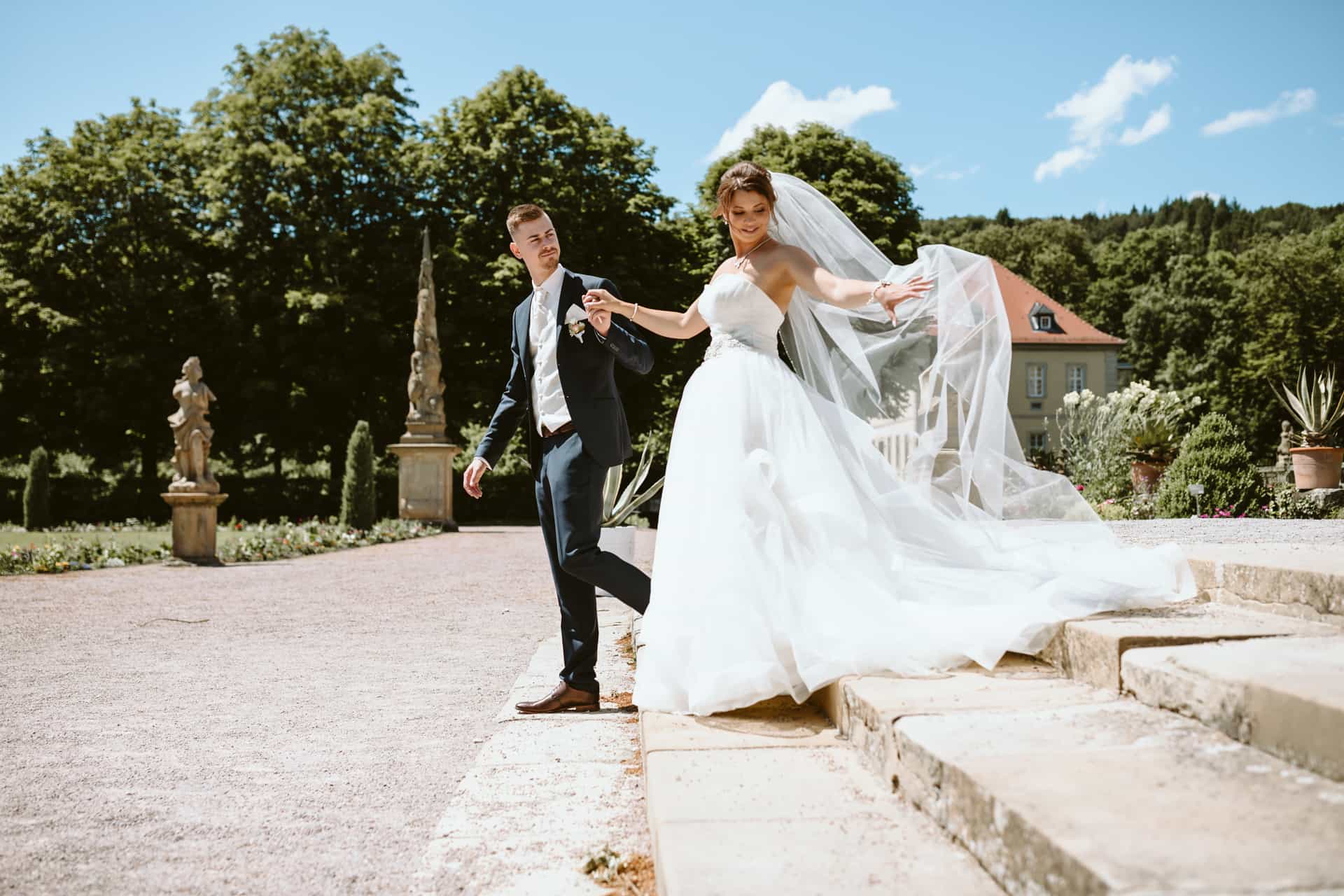 Brautpaar auf einer Treppe im Garten von Schloss Weikersheim