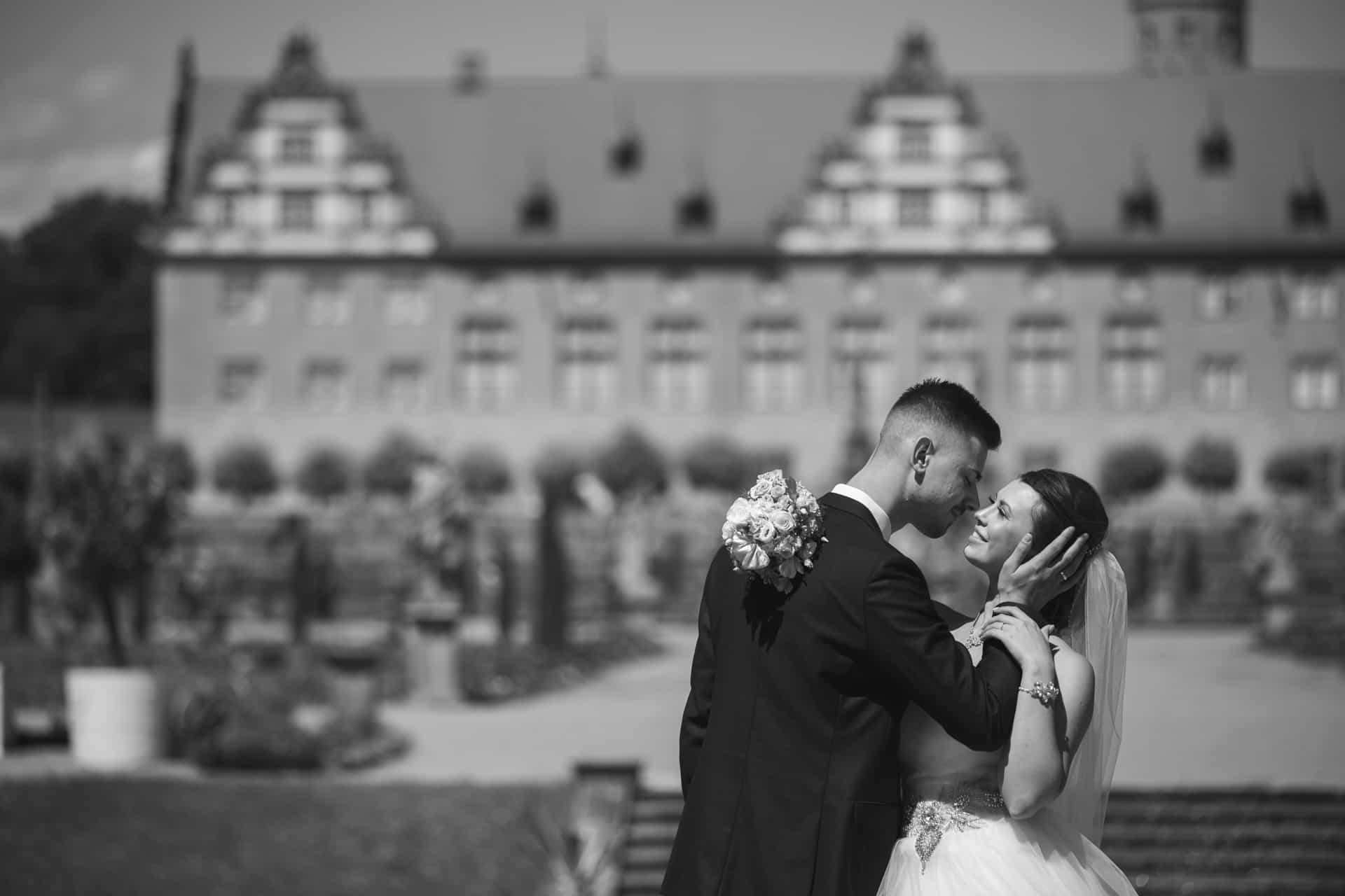 Brautpaar vor der Schlossfassade in Schwarz-Weiß
